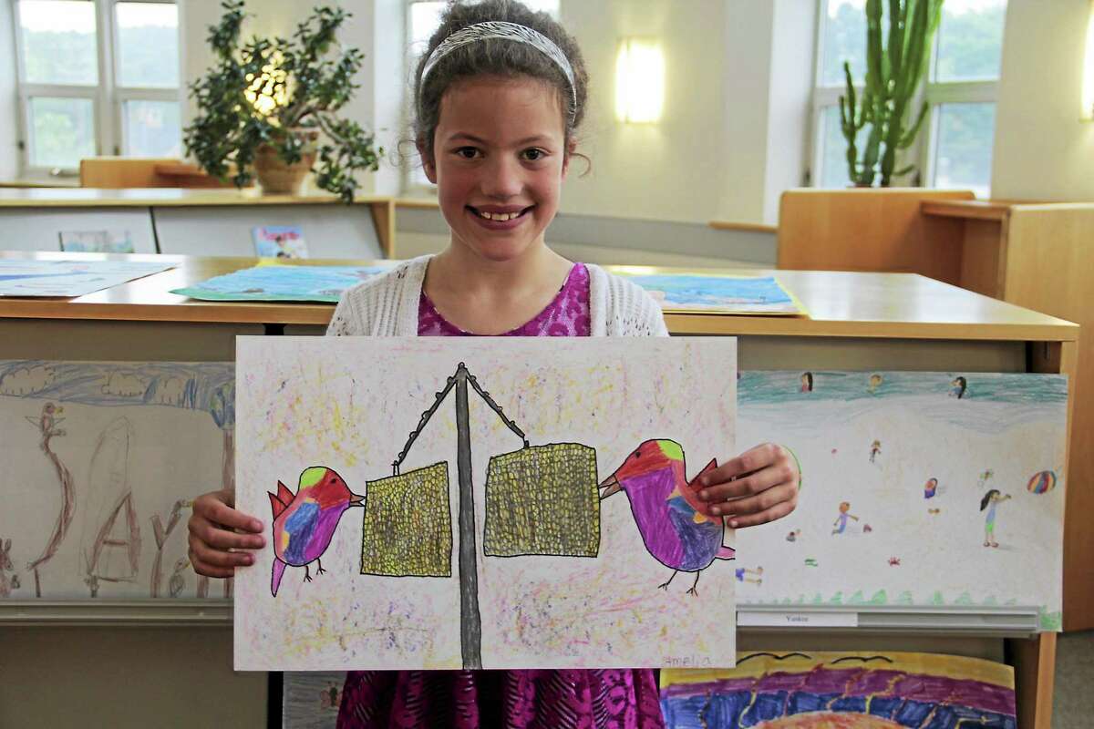 Amelia Ficalori shows her winning poster in the 2015 Peace Poster Contest.