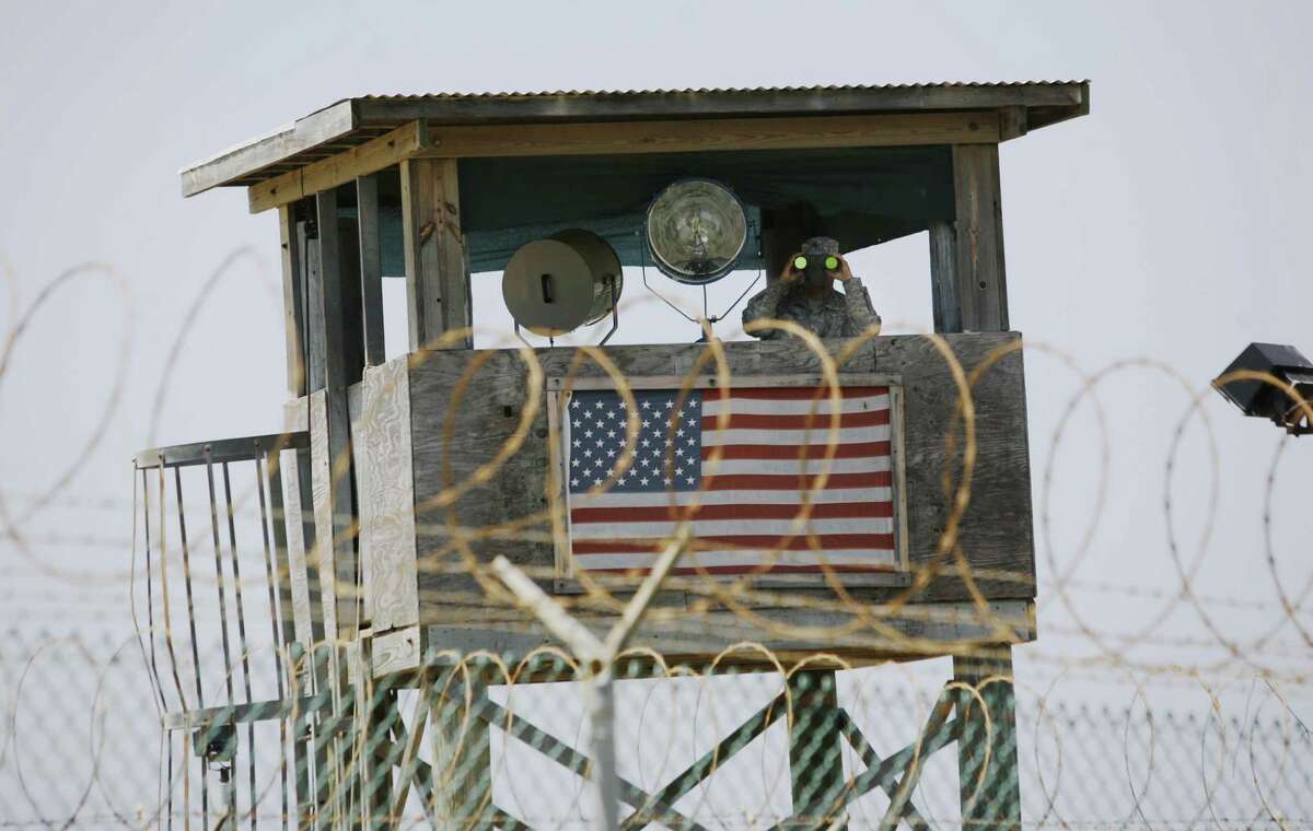 In this May 13, 2008, file photo reviewed by the U.S. Military, a U.S. Army soldier looks through binoculars while standing on a guard tower at Camp 4 in the Guantanamo Bay U.S. Naval Base in Cuba.