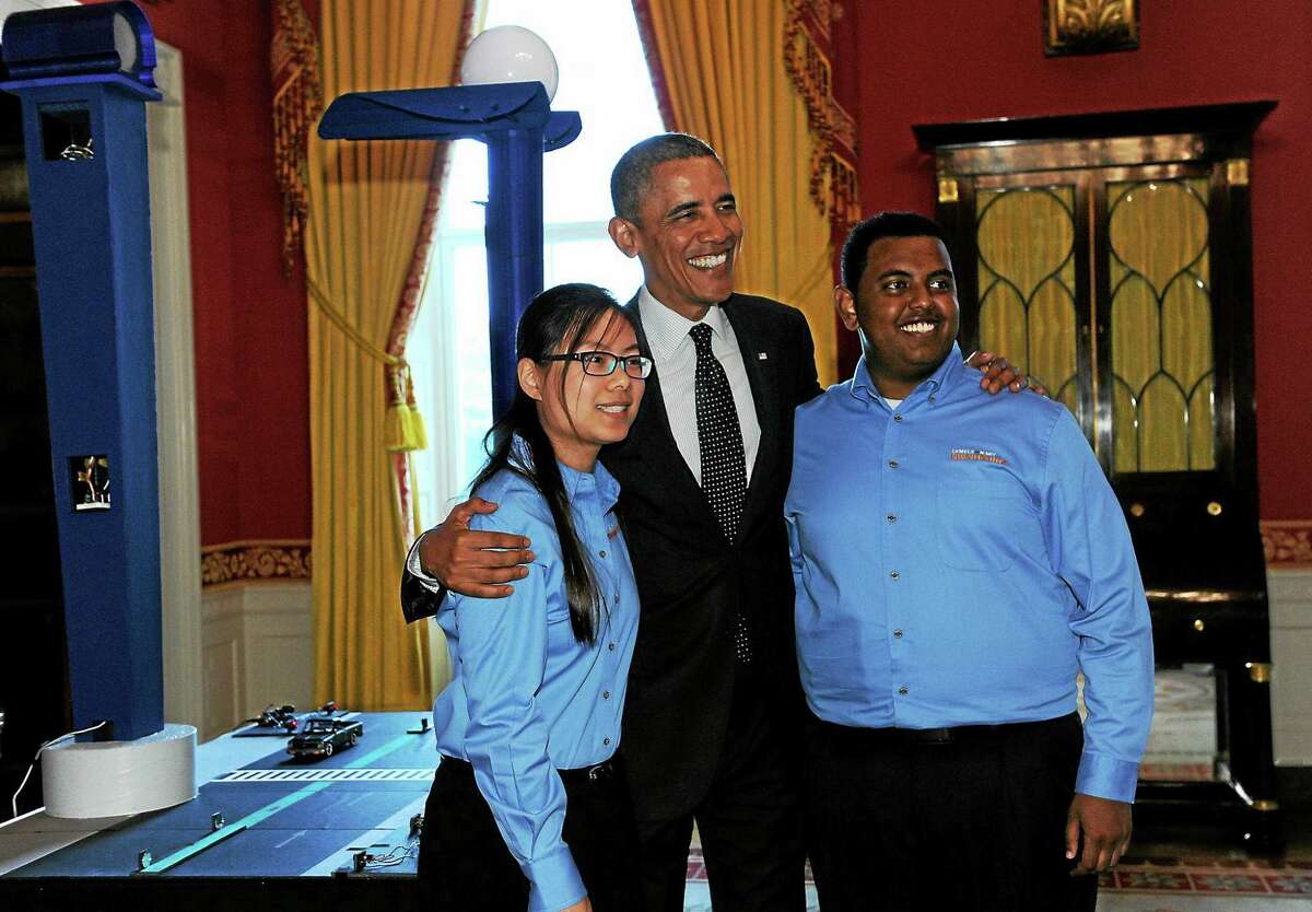 President Barack Obama poses with Karen Fan, 17, left, and Felege Gebru, 18, both of Newton, Mass., as the president toured the 2014 White House Science Fair exhibits on display in the State Dining Room of the White House on May 27, 2014. Obama was celebrating the student winners of a broad range of science, technology, engineering and math (STEM) competitions from across the country.