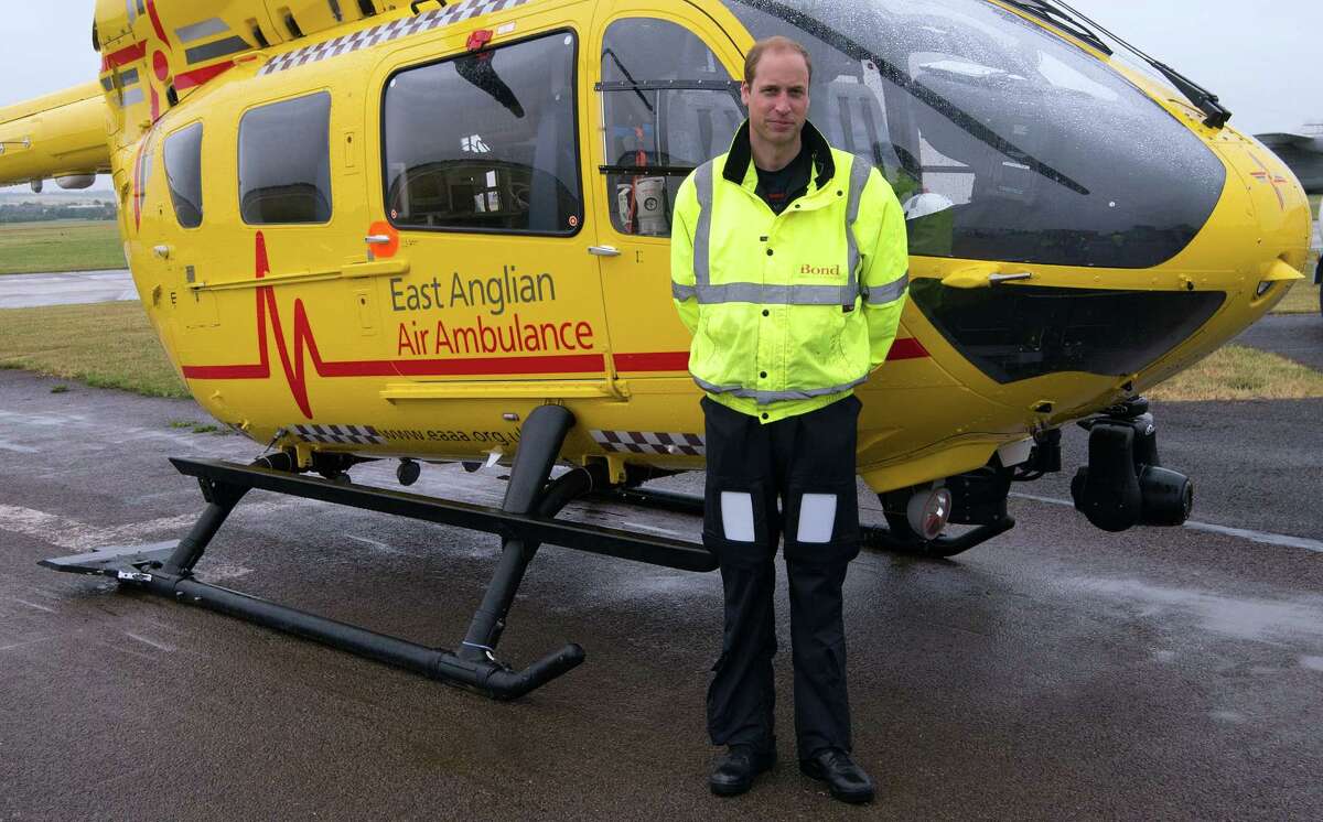 Britain’s Prince William, the Duke of Cambridge poses in front of an East Anglian Air Ambulance (EAAA) as he begins his new role at Cambridge Airport, Cambridge, in England on July 13, 2015.