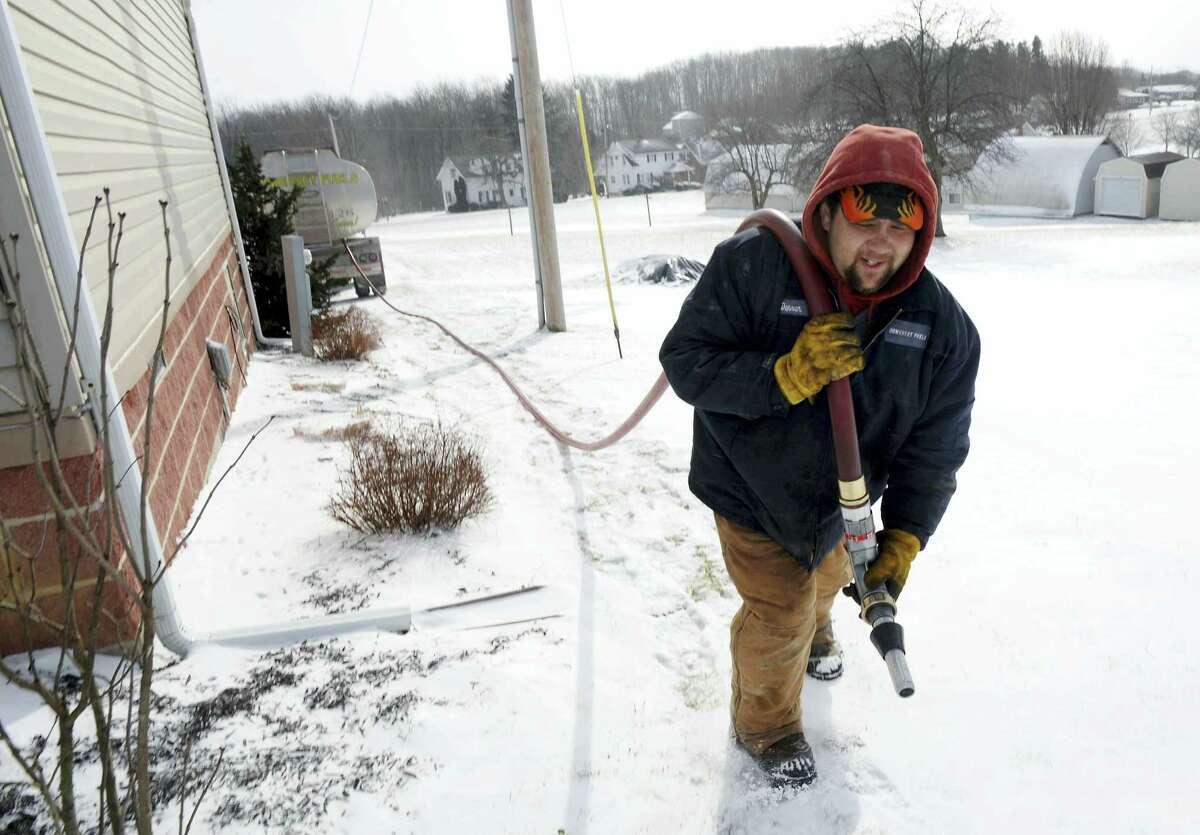 FILE - In this Jan. 7, 2014, file photo, Denver Walker, of Somerset Fuels, makes a heating oil delivery to a home in Jenner Crossroads, Pa. On Thursday, Oct. 13, 2016, the Energy Department said that household bills from October through March are likely to be higher for all four main heating fuels: natural gas, electricity, heating oil and propane. (John Rucosky/The Tribune-Democrat via AP, File)