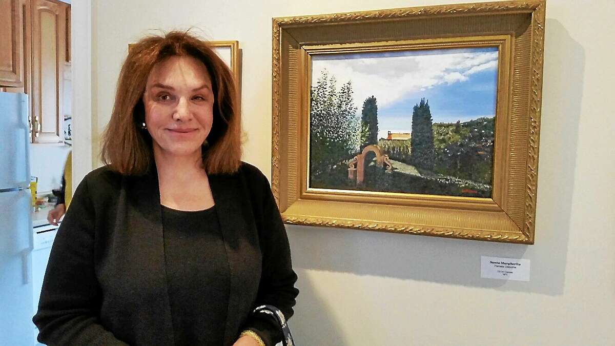 N.F. Ambery - Special to The Register Citizen Pamela Osborne stands besides her oil painting "Santa Margherita" at the Northlight Art Center Student Show's opening reception Saturday afternoon at the Sharon Historical Society & Museum.