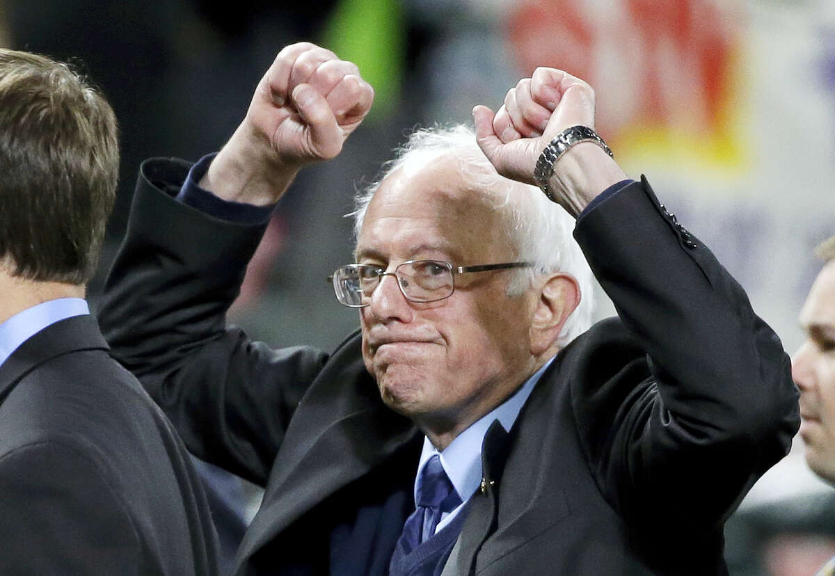 Democratic presidential candidate Sen. Bernie Sanders, I-Vt., pumps his fists as he leaves the field after speaking at a rally Friday, March 25, 2016, in Seattle.