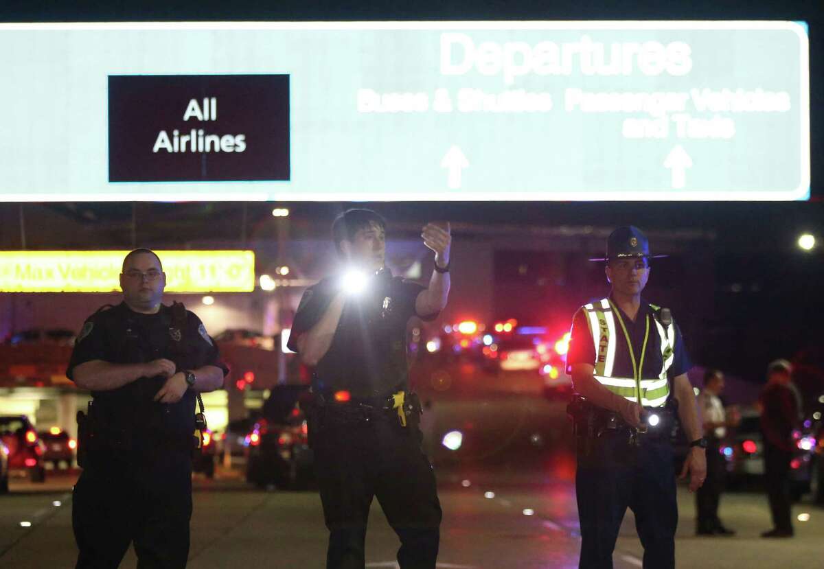 Officers stand at the entrance to New Orleans International Airport, Friday, March 20, 2015, in Kenner, La. Richard White sprayed a TSA agent in the face with wasp killer then slashed a second guard with a machete before a third agent shot him three times at a security checkpoint in the New Orleans international airport Friday. (AP Photos/Jonathan Bachman)