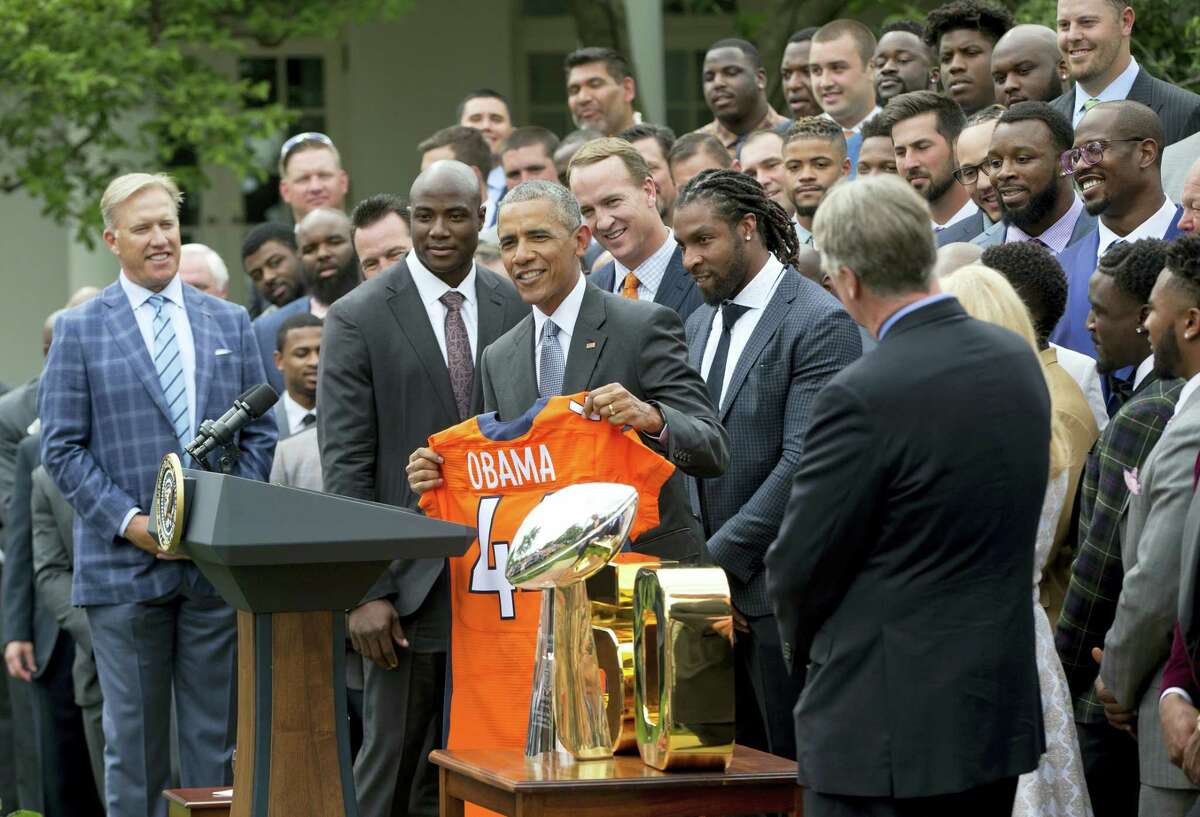 President Barack Obama holds up a Broncos jersey, as he welcomes the Super Bowl Champions during a ceremony in the Rose Garden of the White House in Washington on Monday.