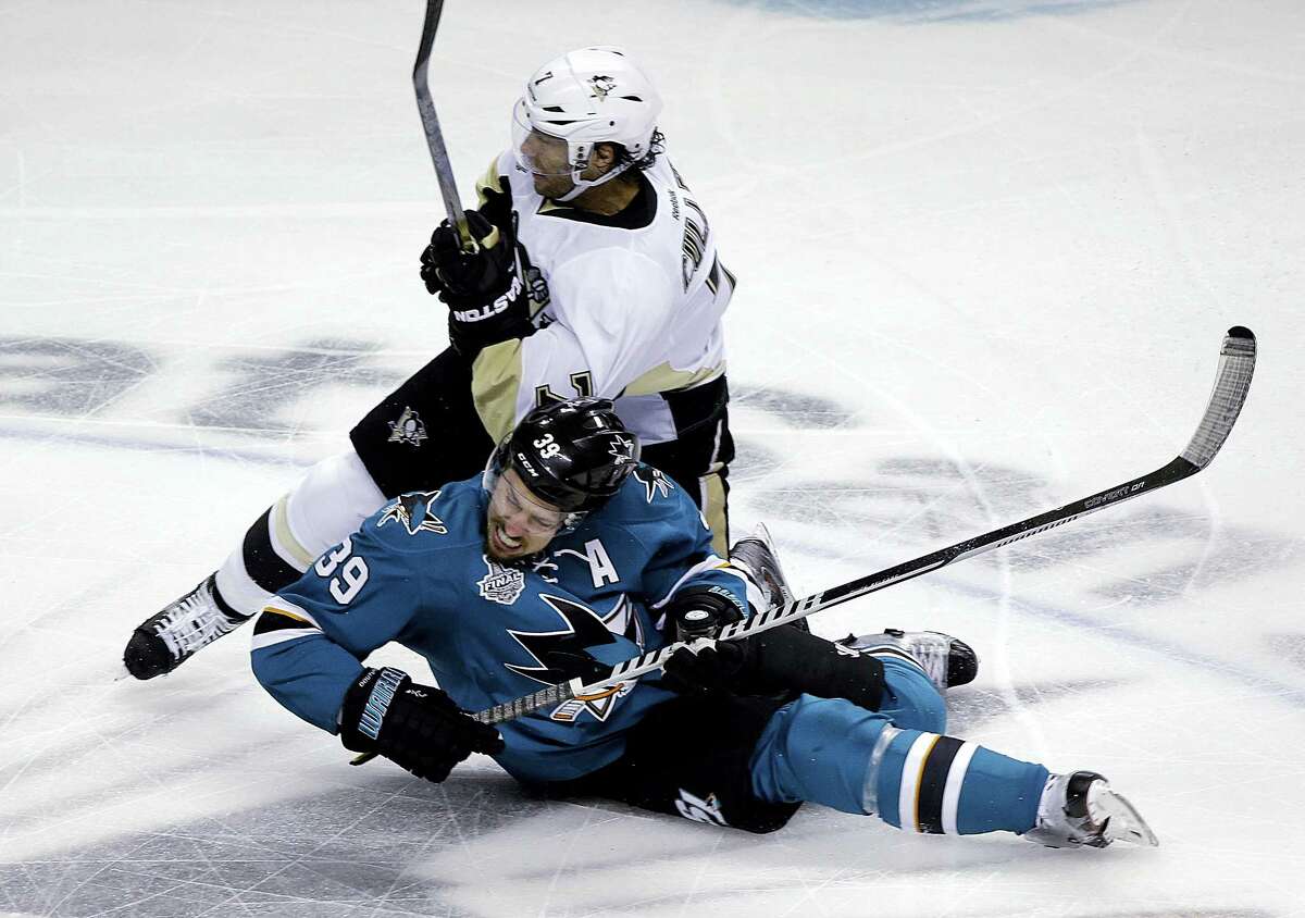 The Penguins’ Matt Cullen, top, collides with the Sharks’ Logan Couture during the first on Monday.