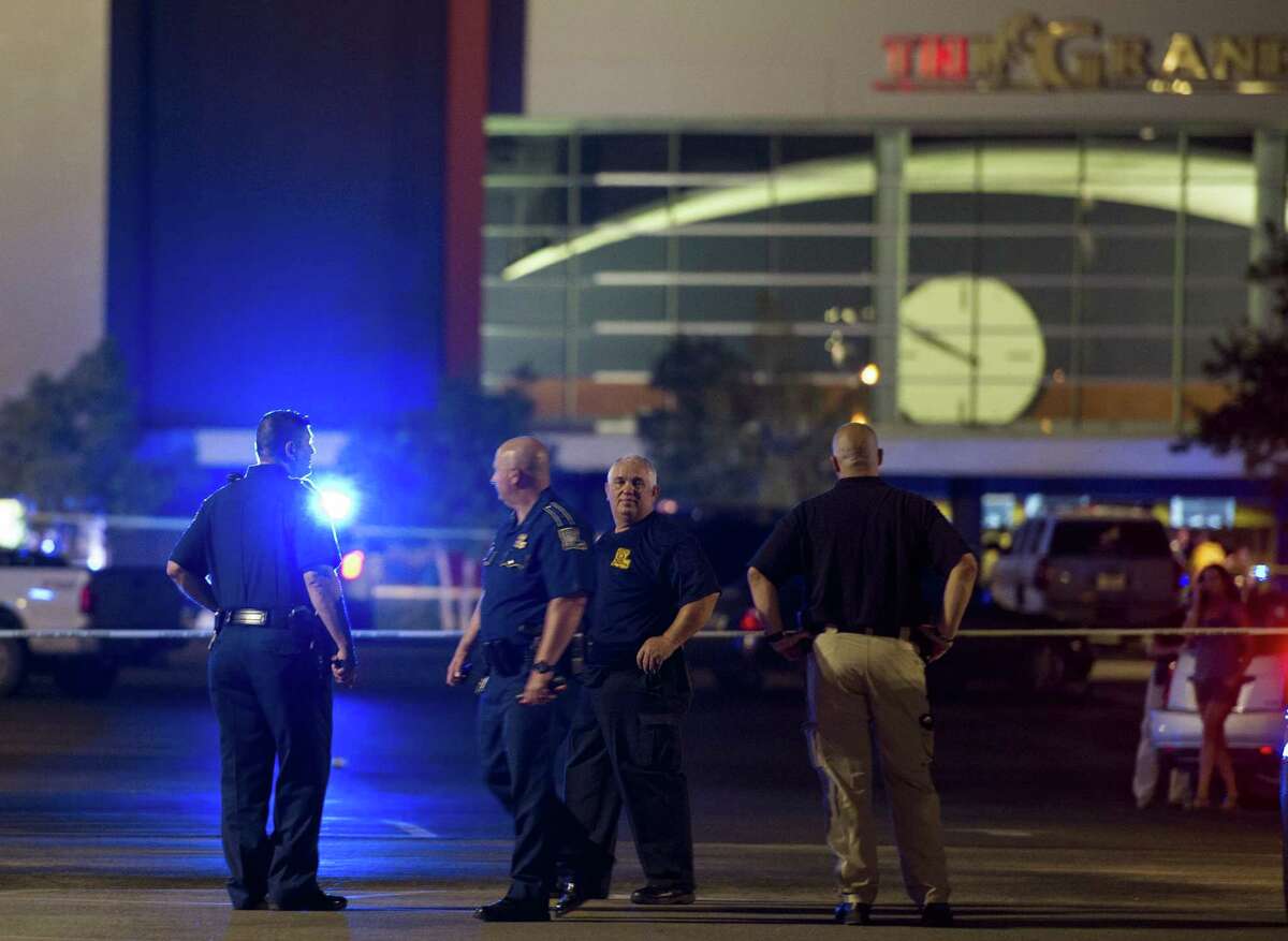 Law enforcement personnel stand near a police line at The Grand Theatre following a deadly shooting in Lafayette, La., Thursday.