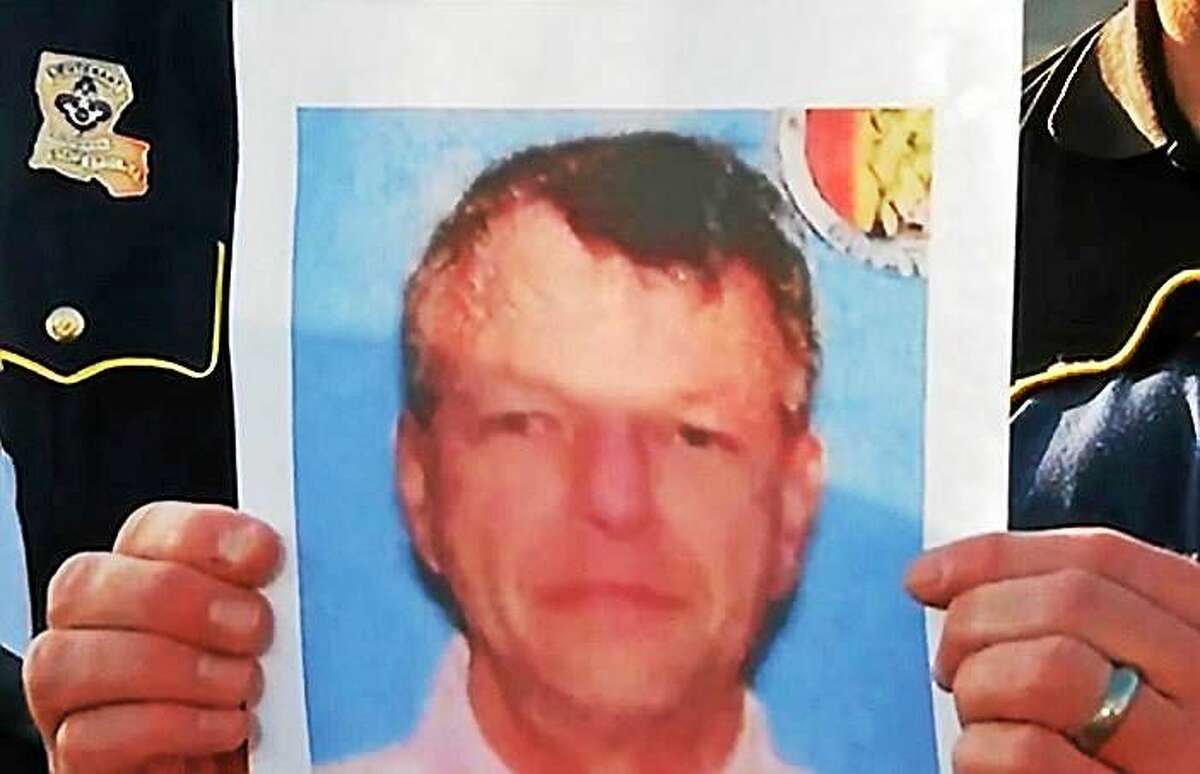 Police held up this photo of John Russell Houser, the man who authorities say opened fire in a Louisiana movie theater Thursdsay night.