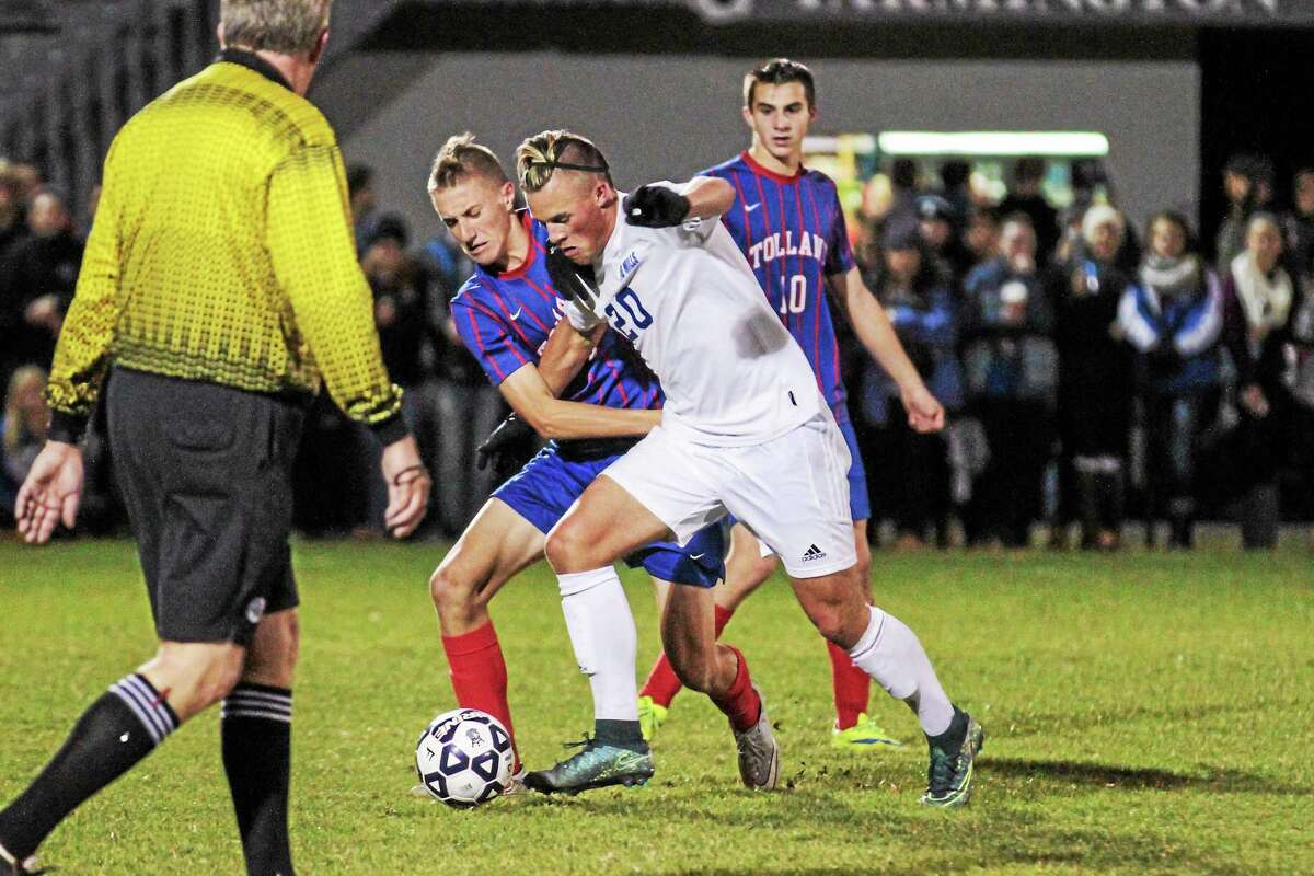 Frederick Marinelli of Lewis Mills and Michael Zimmerman of Tolland battle for control of the ball.