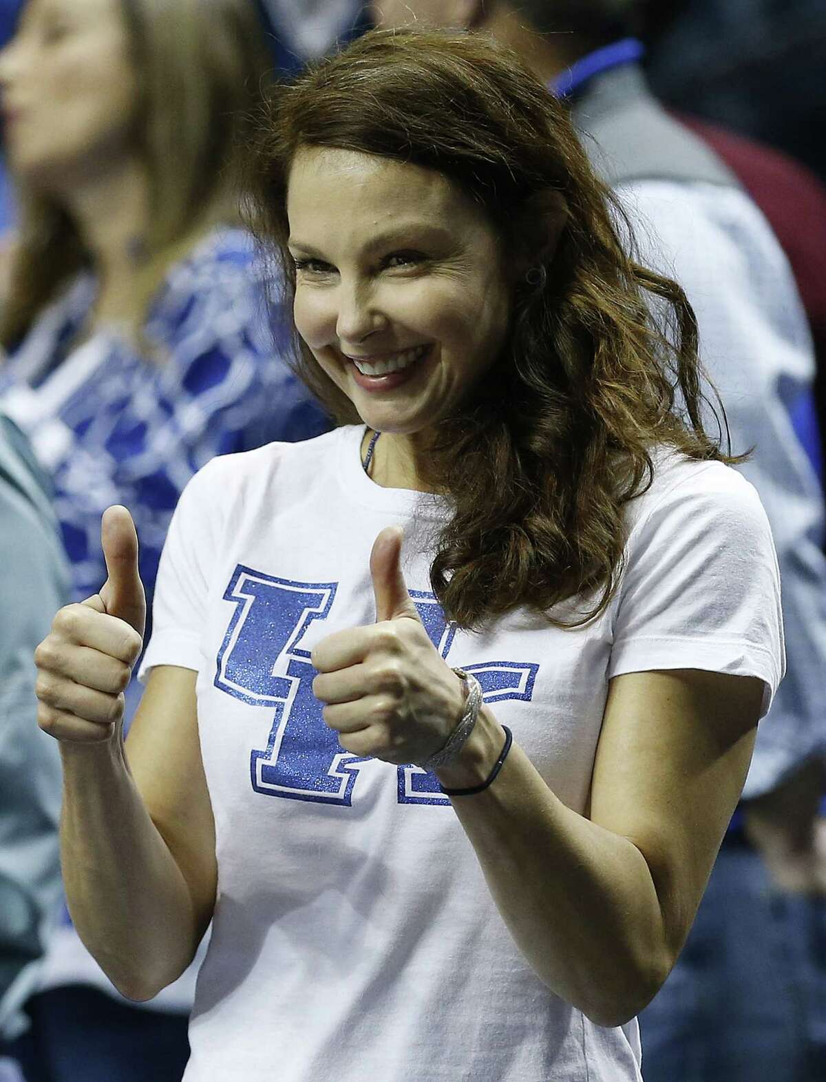 FILE - In this Sunday, March 15, 2015 file photo, actress Ashley Judd motions toward the Kentucky bench before the first half of the NCAA college basketball Southeastern Conference tournament championship game between Kentucky and Arkansas, in Nashville, Tenn. The Kentucky Wildcats fan Judd is firing back at those who posted threats and hateful comments online after she tweeted that she thought Arkansas was playing dirty in its SEC basketball matchup with her alma mater. In an online essay posted Thursday, March 19, 2015, on mic.com, Judd says she routinely copes with tweets that ìsexualize, objectify, insult, degrade and even physically threaten me.î (AP Photo/Steve Helber, File)
