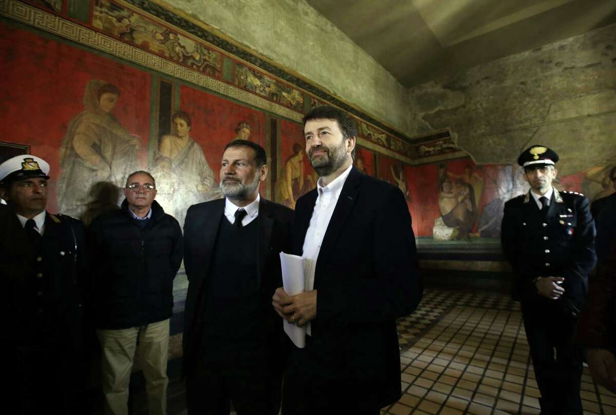 Italian Culture Minister Dario Franceschini, right, flanked by Massimo Osanna, Superintendent for the Archaeological Heritage of Pompeii, stands inside the newly restored Villa of Mysteries on the occasion of its presentation to journalists in the ancient site of Pompeii, Italy, Friday, March 20, 2015. Italy unveiled the restored crown jewel of the ancient city of Pompeii on Friday, showing off a rare success story as it races to shore up the site that has been marred by such mismanagement that it risked losing EU funding and being delisted as a UNESCO world heritage site. (AP Photo/Gregorio Borgia)