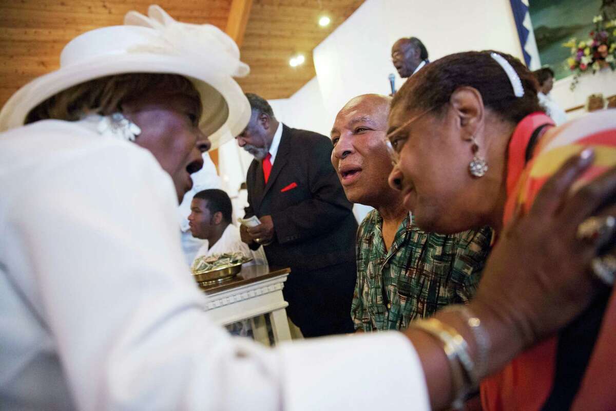 Rahaman Ali, center, brother of Muhammad Ali, and his wife Caroline Ali, right, are greeted by Margaret Machomes as parishioners line up to make a donation in support of the couple during a service at King Solomon Missionary Baptist Church where Ali’s father worshipped and where Muhammad Ali would occasionally accompany him, Sunday, Louisville, Ky.