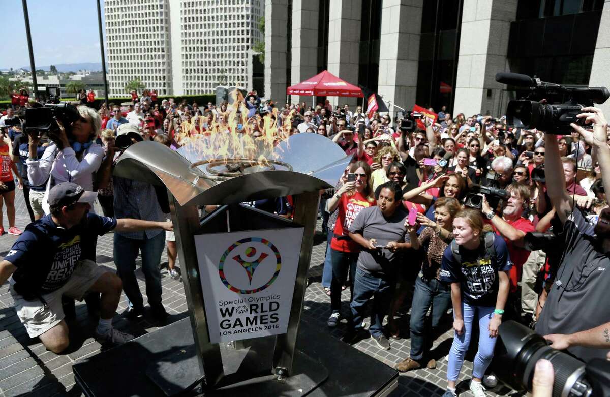 A crowd cheers as torchbearers light the cauldron with the Special Olympic Flame of Hope at South Hope Street Plaza downtown Los Angeles on July 10.