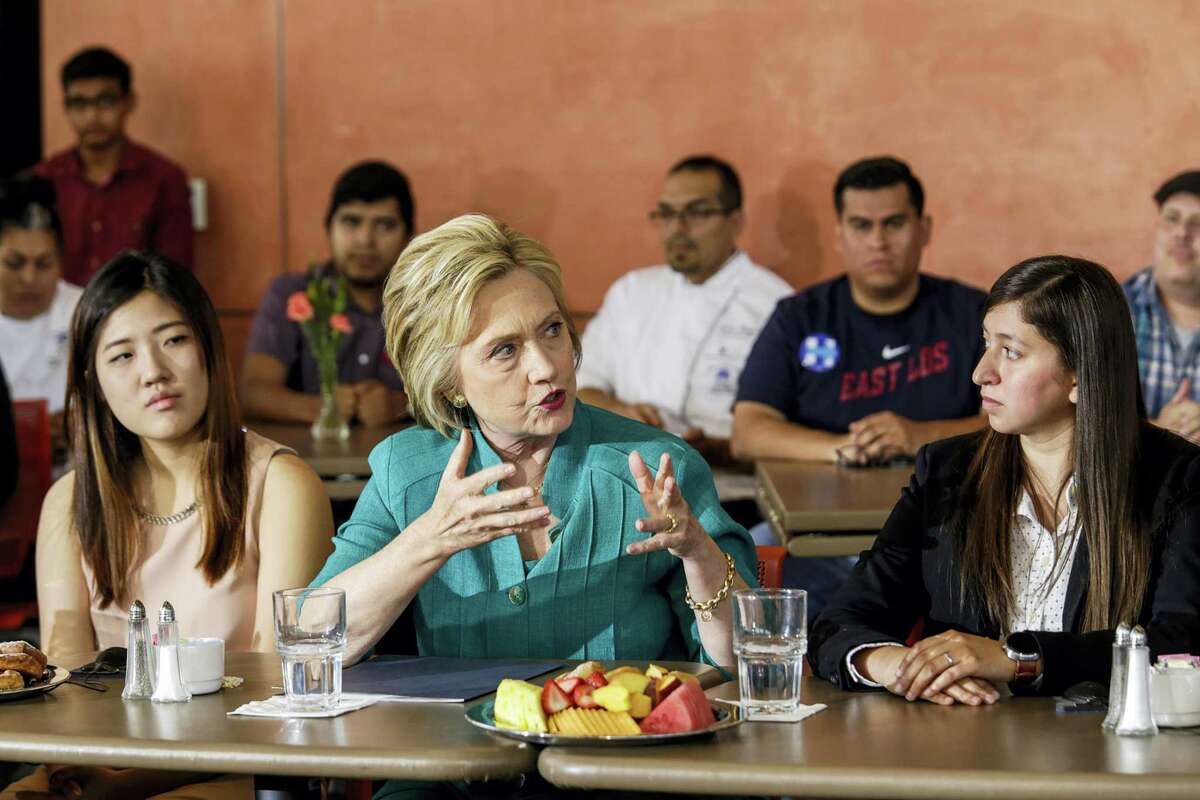 Democratic presidential candidate Hillary Clinton, center, holds a conversation on immigration held at Culinary Arts Institute of Los Angeles Mission College on June 4, 2016 in Sylmar, Calif. Clinton is flanked by Clara Kim, left, and Italia Garcia. They are part of Deferred Action for Childhood Arrivals (DACA) program, an American immigration policy that allows certain illegal immigrants who entered the country before their 16th birthday and before June 2007 to receive a renewable two-year work permit and exemption from deportation.