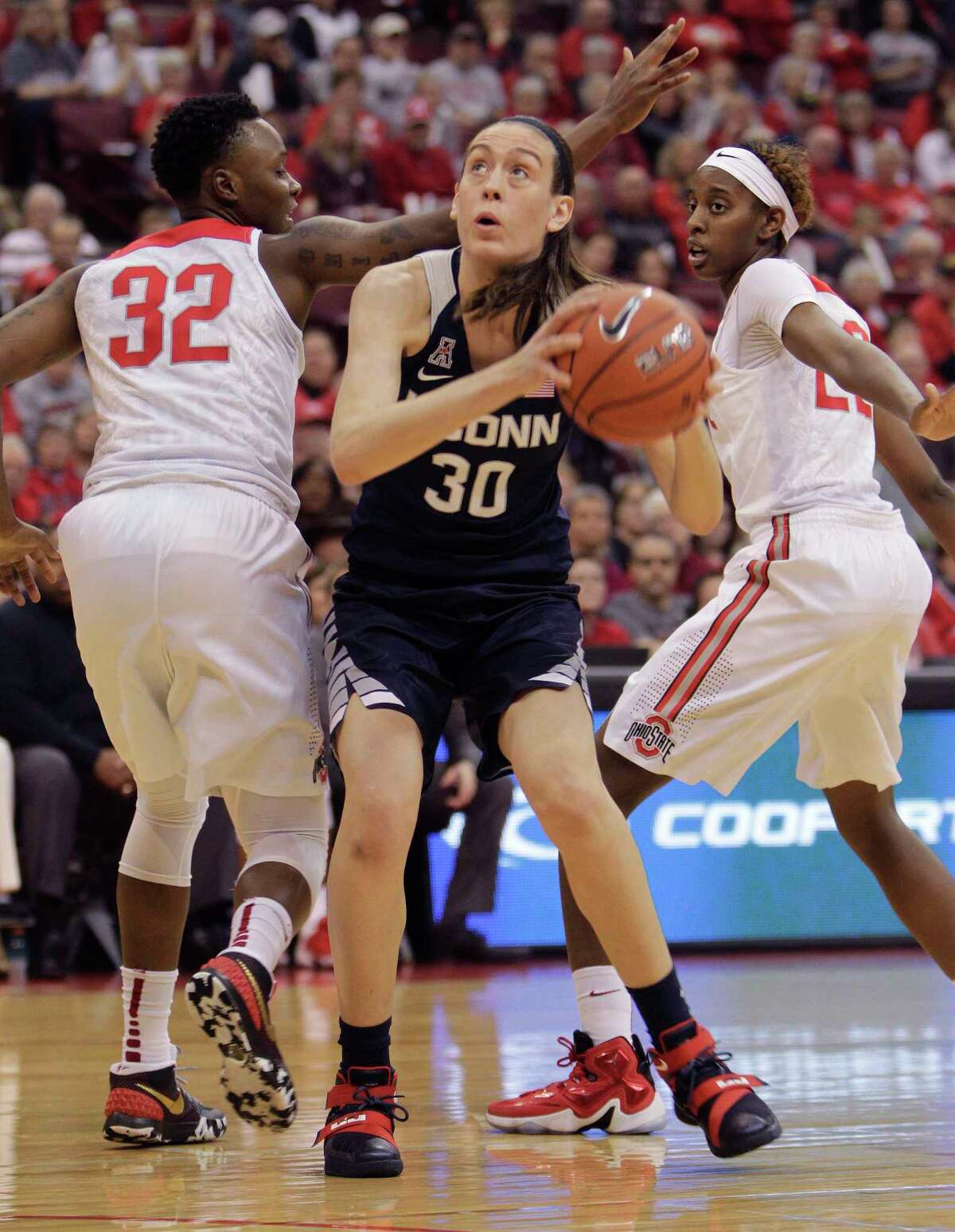 UConn’s Breanna Stewart, center, drives to the basket between Ohio State’s Shayla Cooper, left, and Alexa Hart during the first quarter Monday.