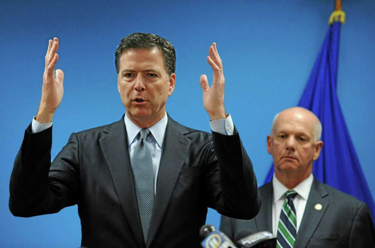 In this July 30, 2014 photo, James Comey, Director of the Federal Bureau of Investigation, left, speaks to the media with U.S. Attorney David J. Hickton at the FBI’s Pittsburgh headquarters.