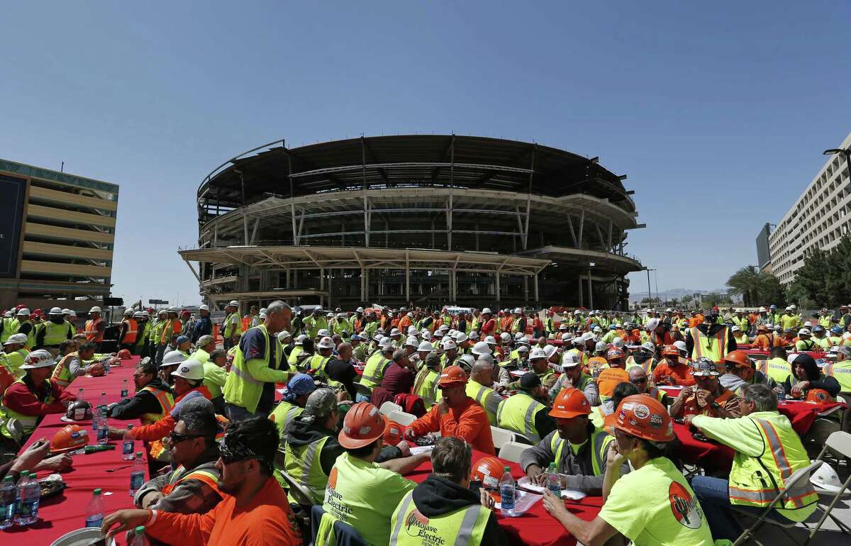 In this April 7 file photo, construction works eat lunch by an MGM arena being built behind the New York-New York casino-hotel in Las Vegas.