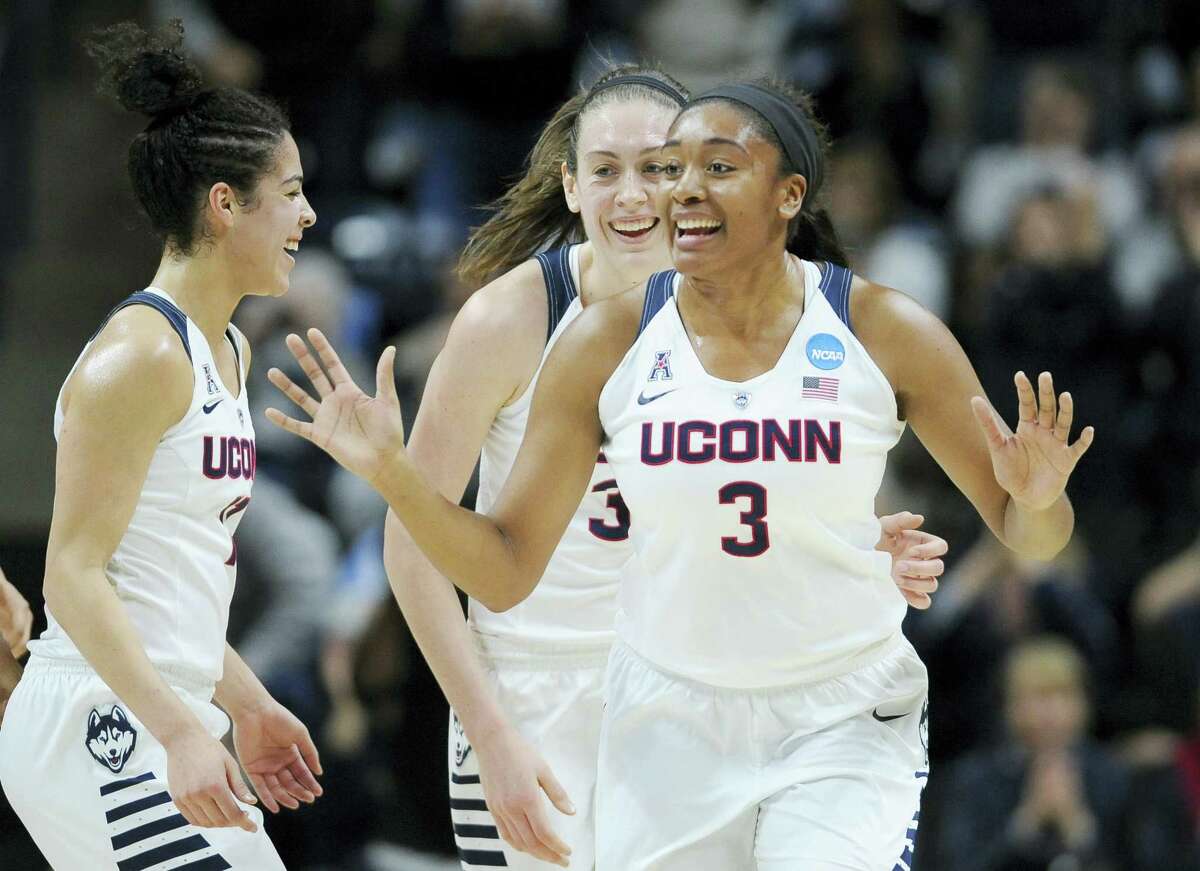 UConn’s Morgan Tuck, right, celebrates with Kia Nurse, left, and Breanna Stewart, rear, after sinking a basket during the first half of Monday’s game against Duquesne.