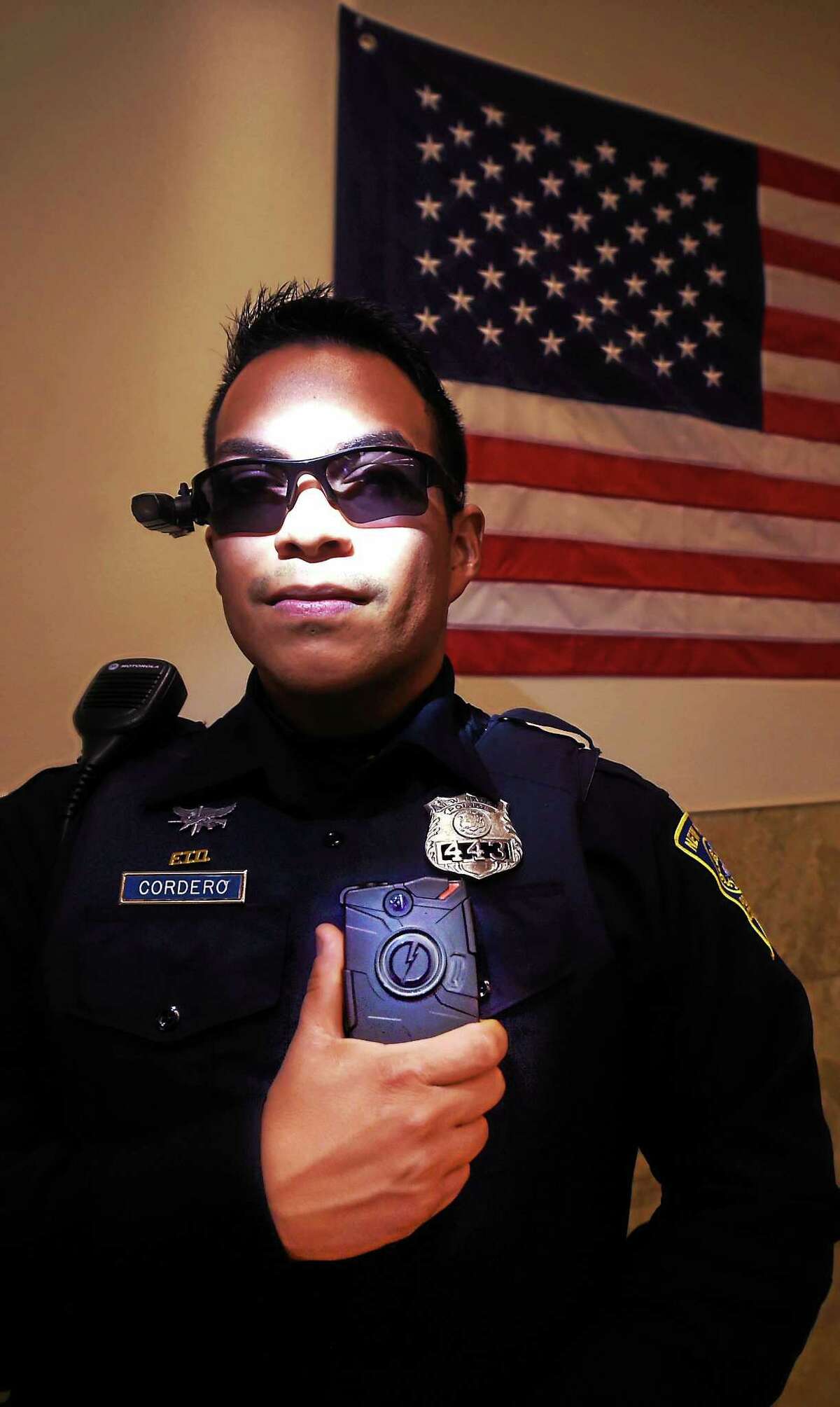 New Haven Police Officer Jeremy Cordero wears sunglasses equipped with a police body camera and also holds a body camera attached to his uniform. The body cameras are part of an NHPD pilot program testing three different body cameras. Friday November 13, 2015.