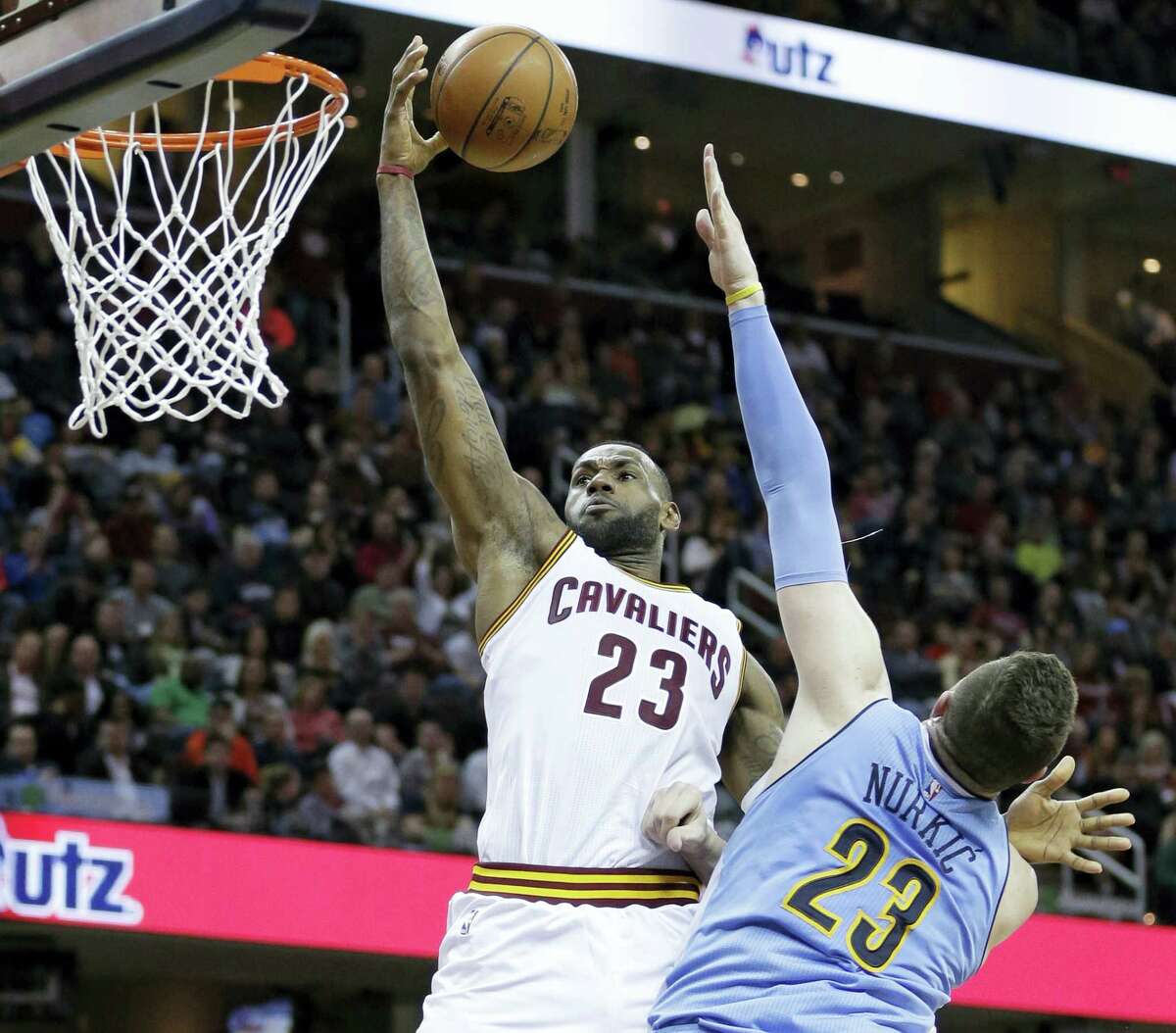 LeBron James, left, drives to the basket against the Nuggets’ Jusuf Nurkic on Monday in Cleveland.