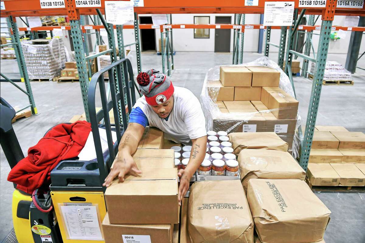 (Arnold Gold-New Haven Register) Usef Norwood puts together an order in the warehouse of the new Connecticut Food Bank facility.