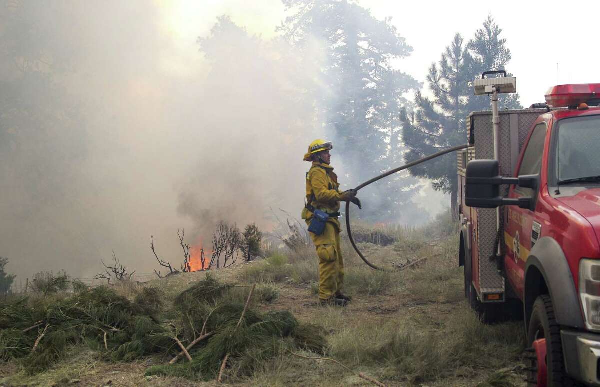 A Los Angeles County firefighter fights a fire near Wrightwood, Calif. on July 18, 2015.
