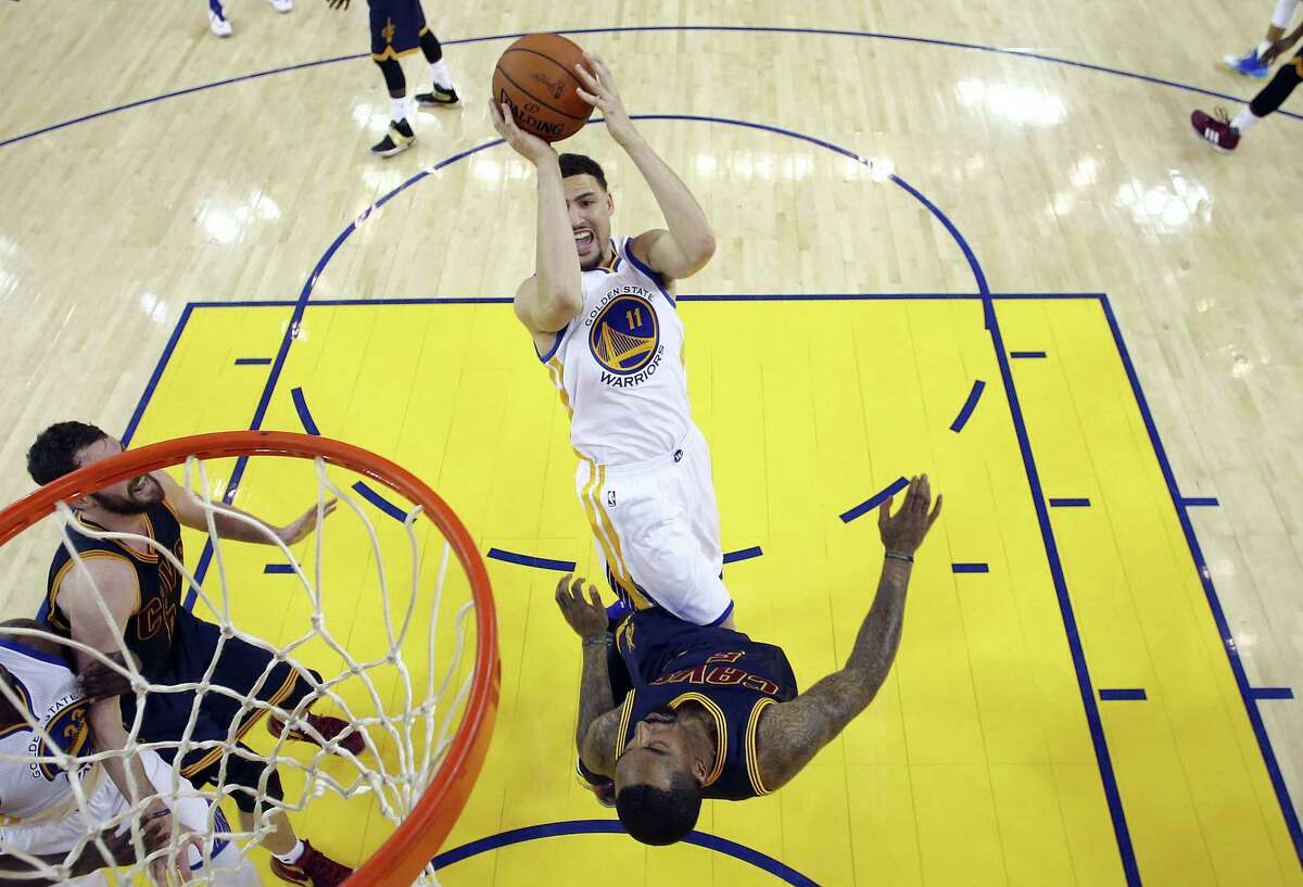 Warriors guard Klay Thompson (11) shoots over Cavaliers guard J.R. Smith during the first half of Game 1 of the NBA Finals on Thursday.