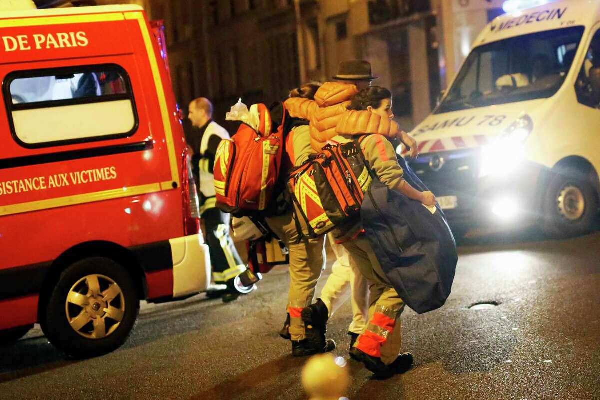 A victim is evacuated after a shooting, near the Bataclan theater in Paris, Friday Nov. 13, 2015. Well over 100 people were killed in a series of shooting and explosions explosions. French President Francois Hollande declared a state of emergency and announced that he was closing the country’s borders.