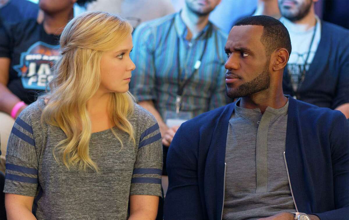 This image released by Universal Pictures shows Amy Schumer, left, and LeBron James, in a scene from the comedy, “Trainwreck.”