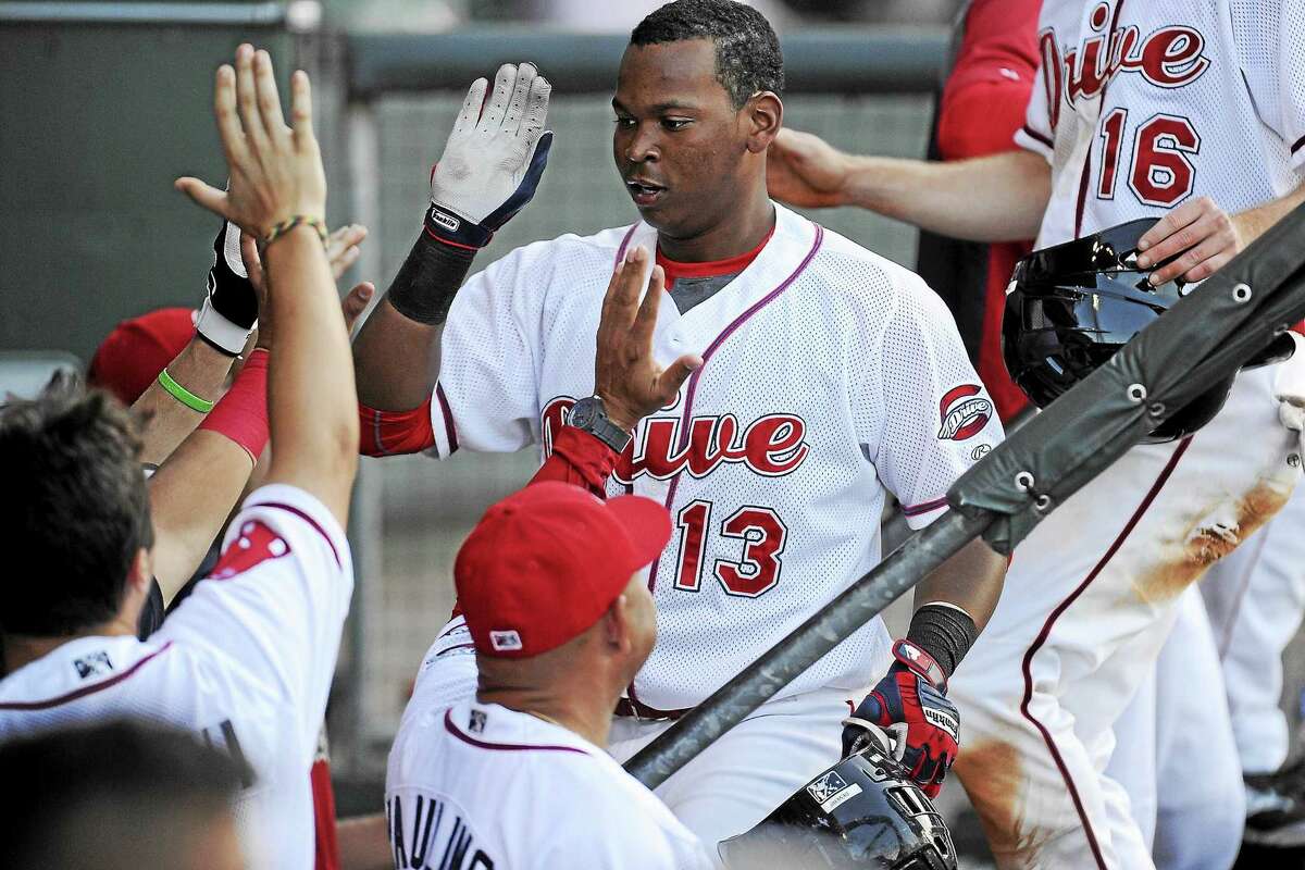 Rafael Devers (13) of the Greenville Drive is congratulated after scoring a run in a game against the Charleston RiverDogs on May 24 in Greenville, South Carolina.