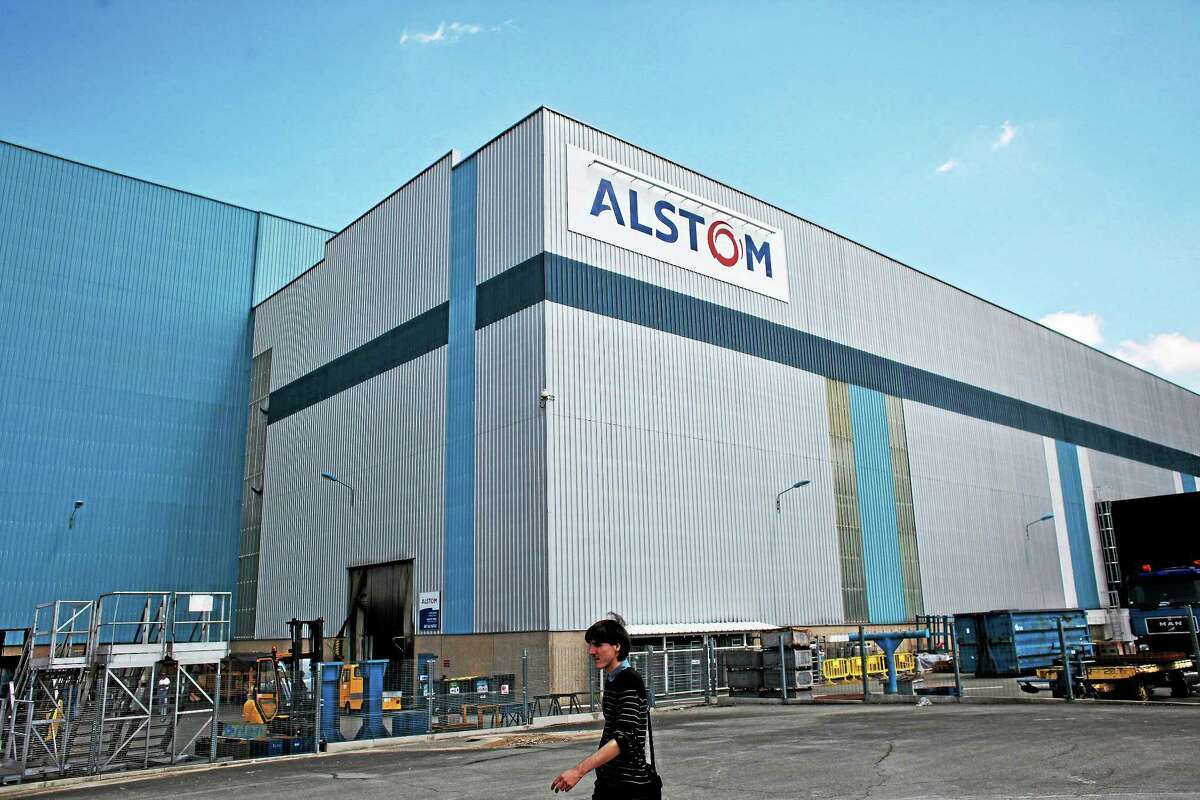 A man walks in front of the Alstom plant in Belfort, eastern France, Tuesday, June 24, 2014.