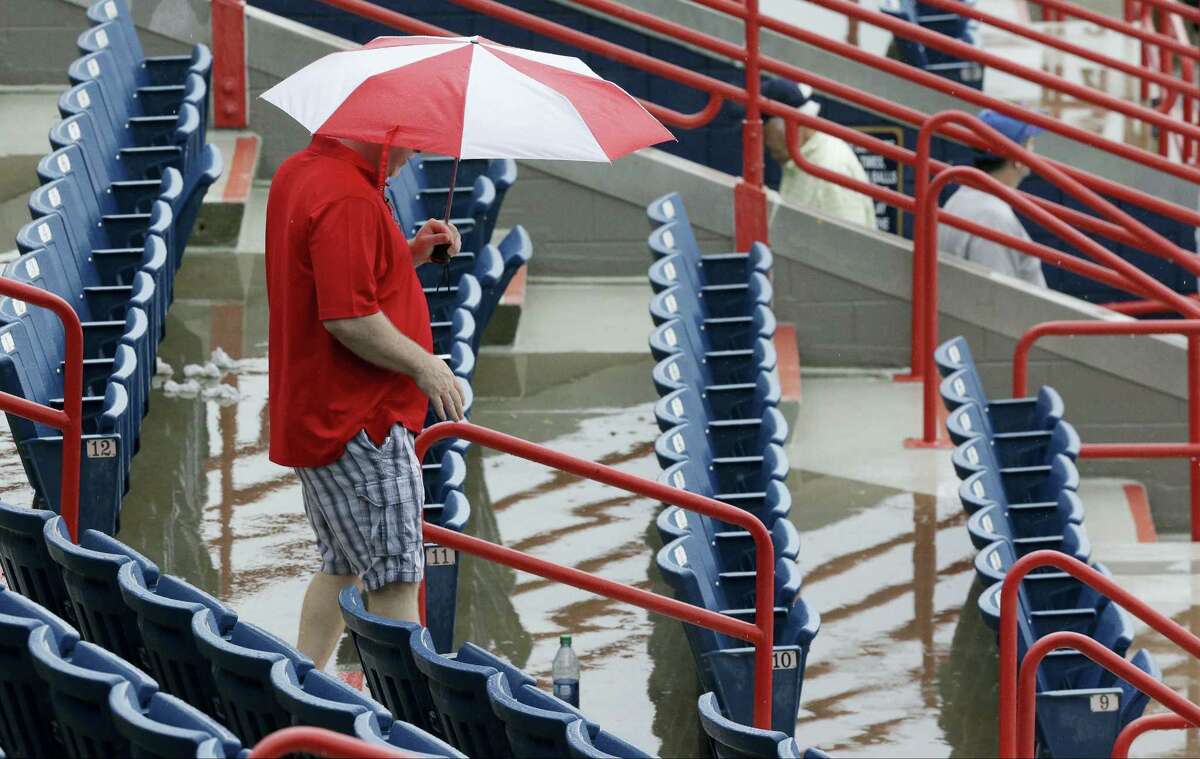 A fan exits a spring training game between the Nationals and Mets after it was cancelled because of rain on Saturday in Viera, Fla.