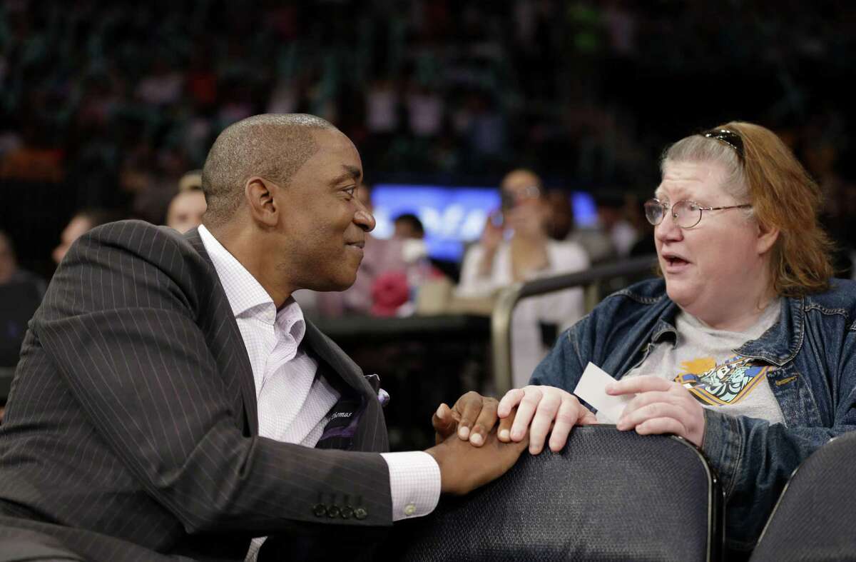 New York Liberty President Isiah Thomas, left, talks with a fan during the first half of the WNBA game between the Liberty and the San Antonio Stars in New York.