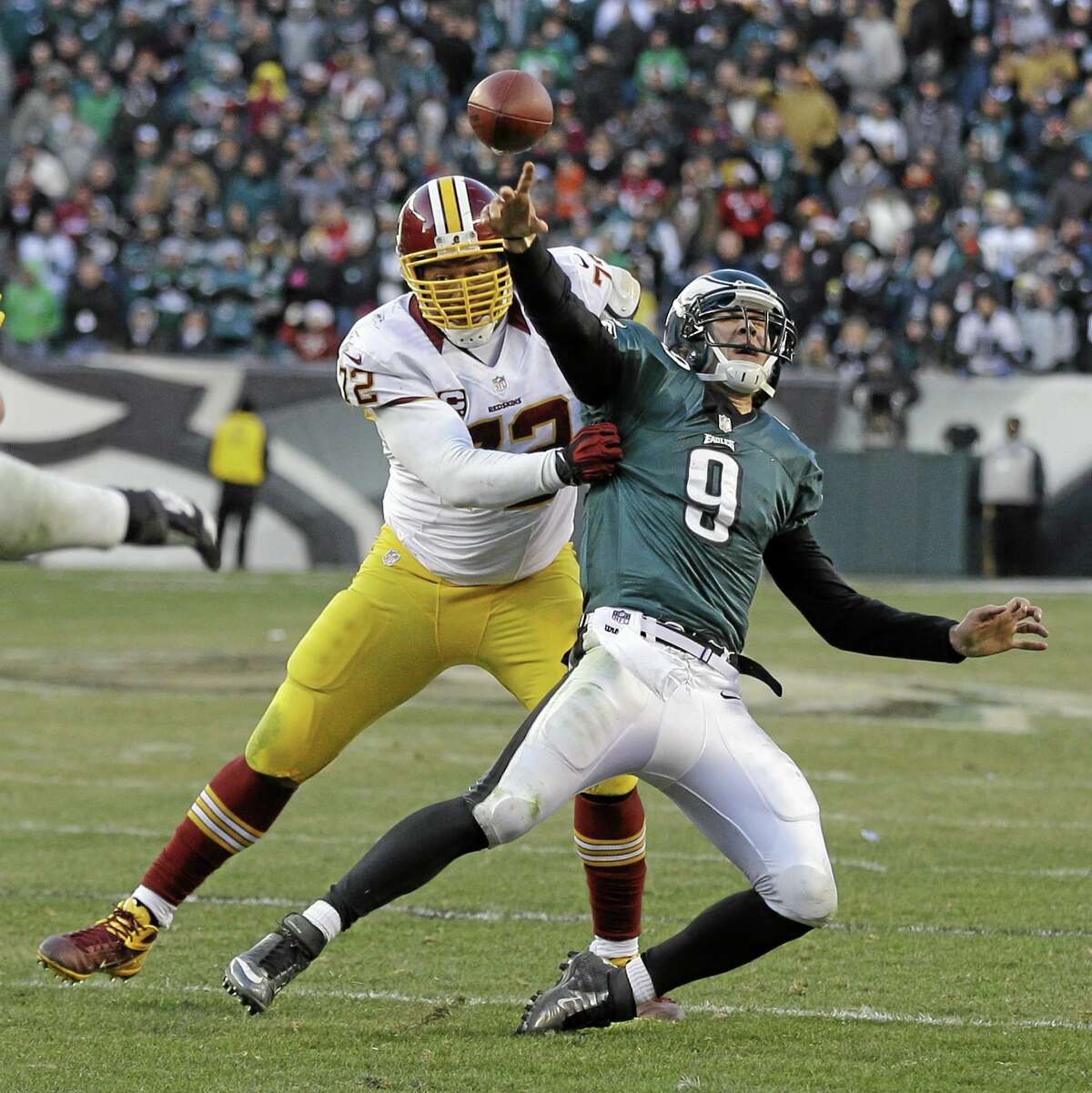 Philadelphia Eagles’ Nick Foles passes the ball as Washington Redskins’ Stephen Bowen brings him down during the final seconds of an NFL football game on Dec. 23, 2012, in Philadelphia. Foles was called for intentional grounding on the game-ending play. Washington won 27-20.