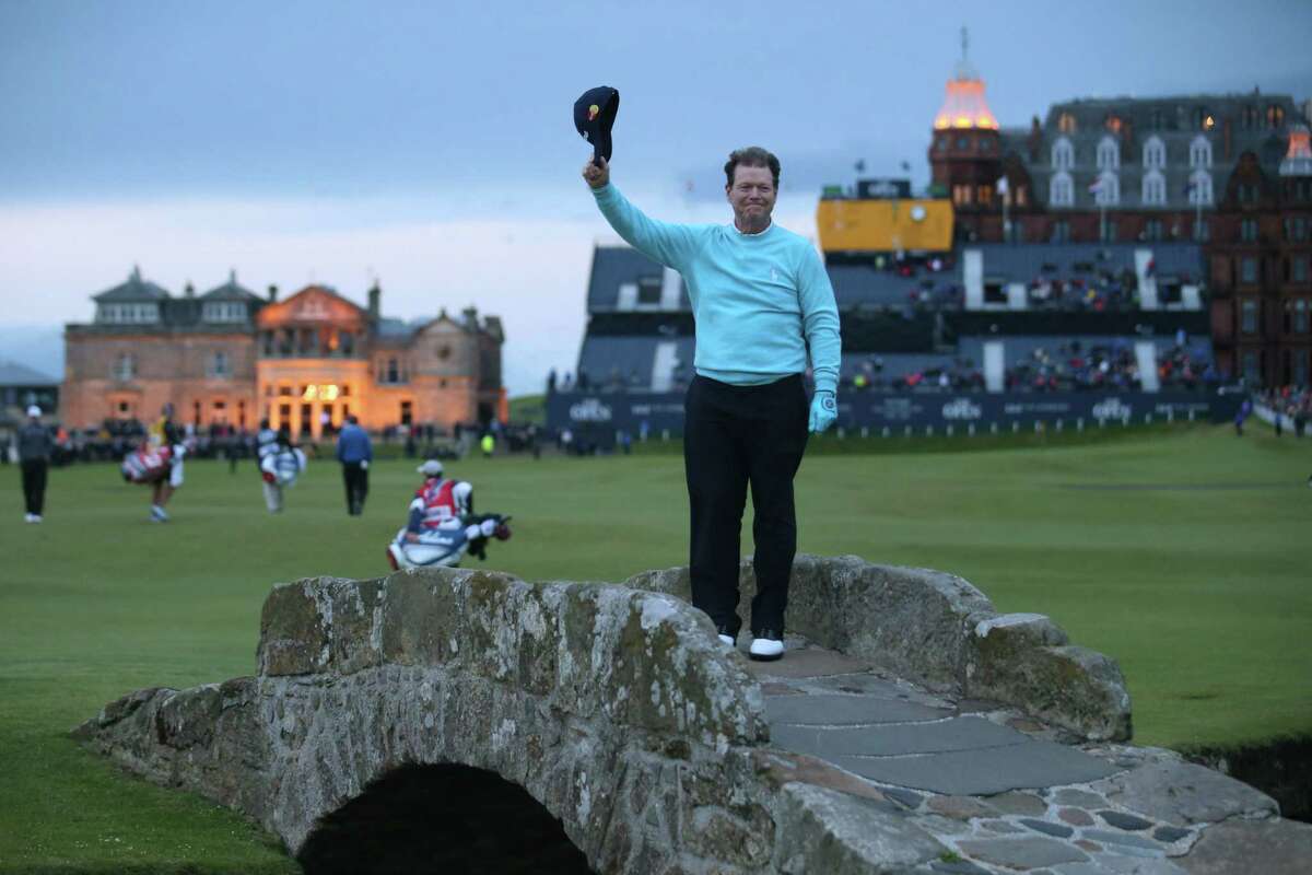 Tom Watson doffs his cap as he poses on the Swilcan Bridge for photographers during the second round of the British Open.