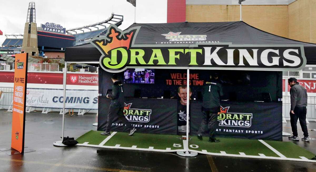 In this Oct. 25, 2015 photo, workers set up a DraftKings promotions tent in the parking lot of Gillette Stadium, in Foxborough, Mass. before an NFL football game between the New England Patriots and New York Jets. New York’s attorney general on Tuesday, Nov. 10, 2015, ordered the daily fantasy sports companies DraftKings and FanDuel to stop accepting bets in the state, saying their operations amount to illegal gambling.