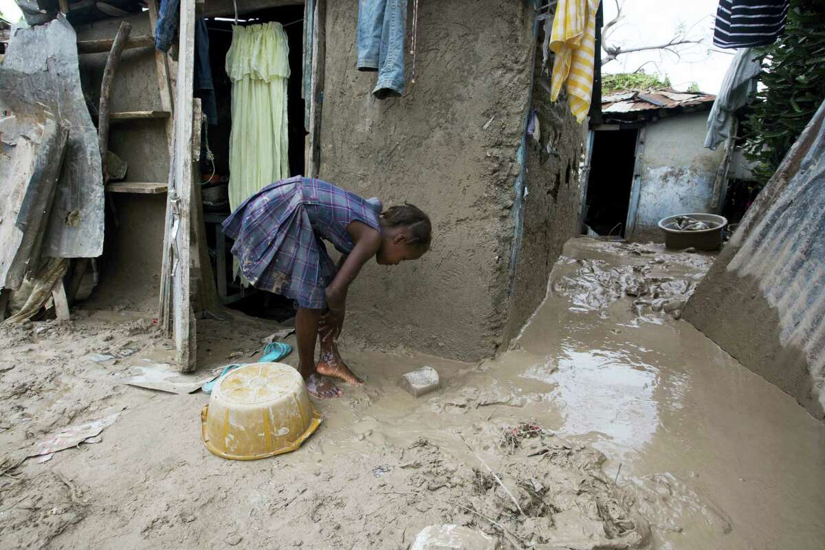 A girl washes mud from her feet after Hurricane Matthew passed in Les Cayes, Haiti, Thursday, Oct. 6, 2016. Two days after the storm rampaged across the country’s remote southwestern peninsula, authorities and aid workers still lack a clear picture of what they fear is the country’s biggest disaster in years.