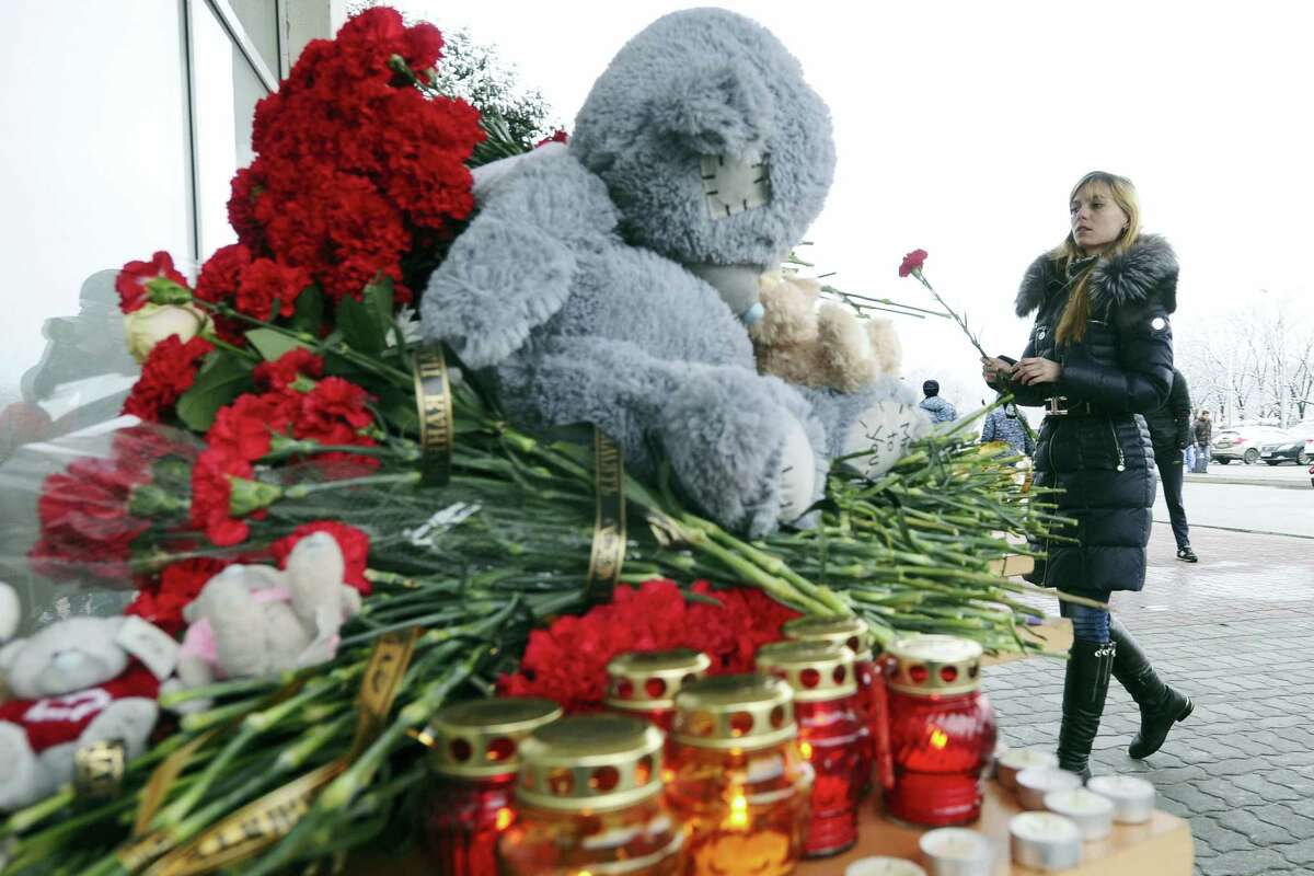 A woman puts a red flower next to toys, flowers and candles in memory of victims of the crashed plane at the Rostov-on-Don airport, about 950 kilometers (600 miles) south of Moscow, Russia Saturday, March 19, 2016. A Dubai airliner crashed and caught fire early Saturday while landing in strong winds in the southern Russian city of Rostov-on-Don, officials said.