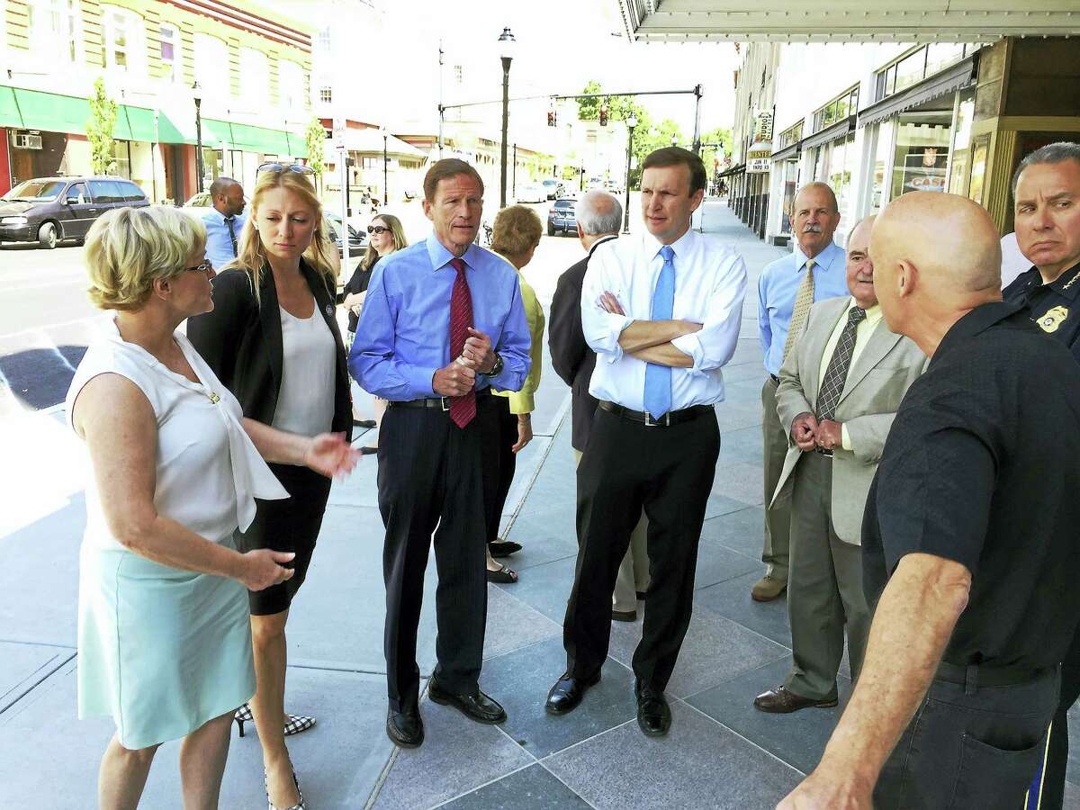 From left, Torrington Mayor Elinor Carbone, state Rep. Michelle Cook, and U.S. Sens. Richard Blumenthal and Chris Murphy, along with police and town officials, discuss the city’s recently completed sidewalk replacement project on Main Street Wednesday morning.