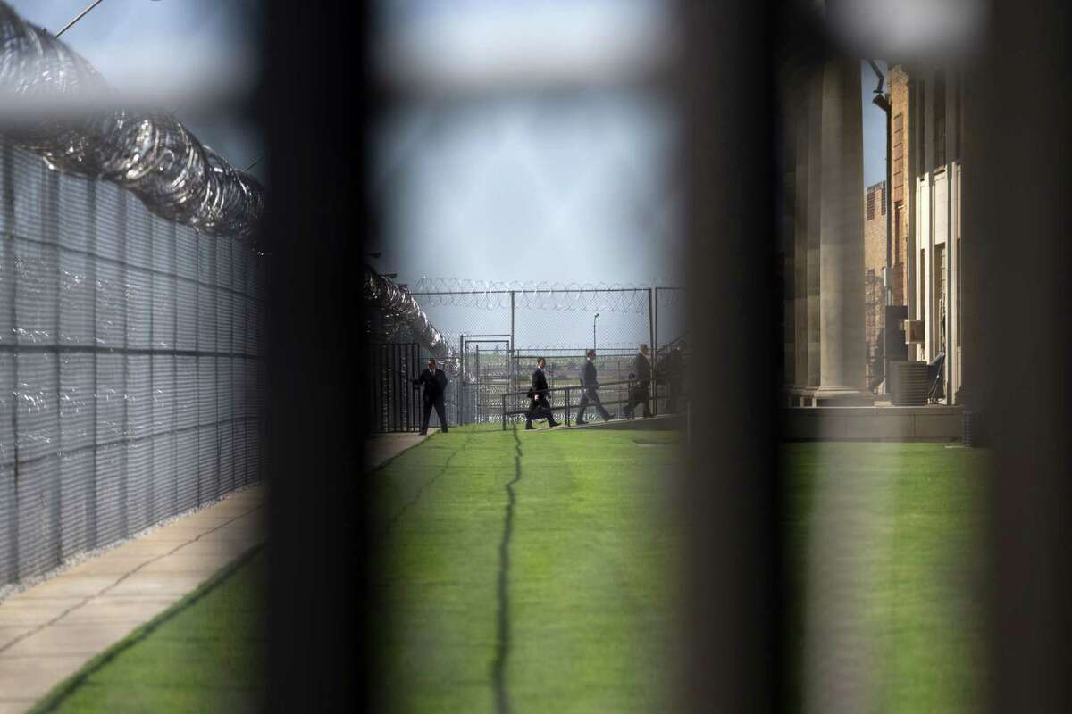 White House staff walk into the El Reno Federal Correctional Institution in El Reno, Okla., Thursday, July 16, 2015. As part of a weeklong focus on inequities in the criminal justice system, the president will meet separately Thursday with law enforcement officials and nonviolent drug offenders who are paying their debt to society at the El Reno Federal Correctional Institution, a medium-security prison for male offenders near Oklahoma City. (AP Photo/Evan Vucci)