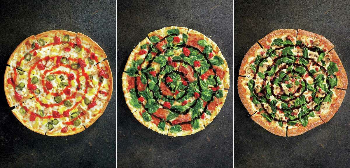 This product image provided by Pizza Hut shows the restaurant chain’s specialty pizzas: from left, Sweet Sriracha Dynamite, Cherry Pepper Bombshell, and Pretzel Piggy.