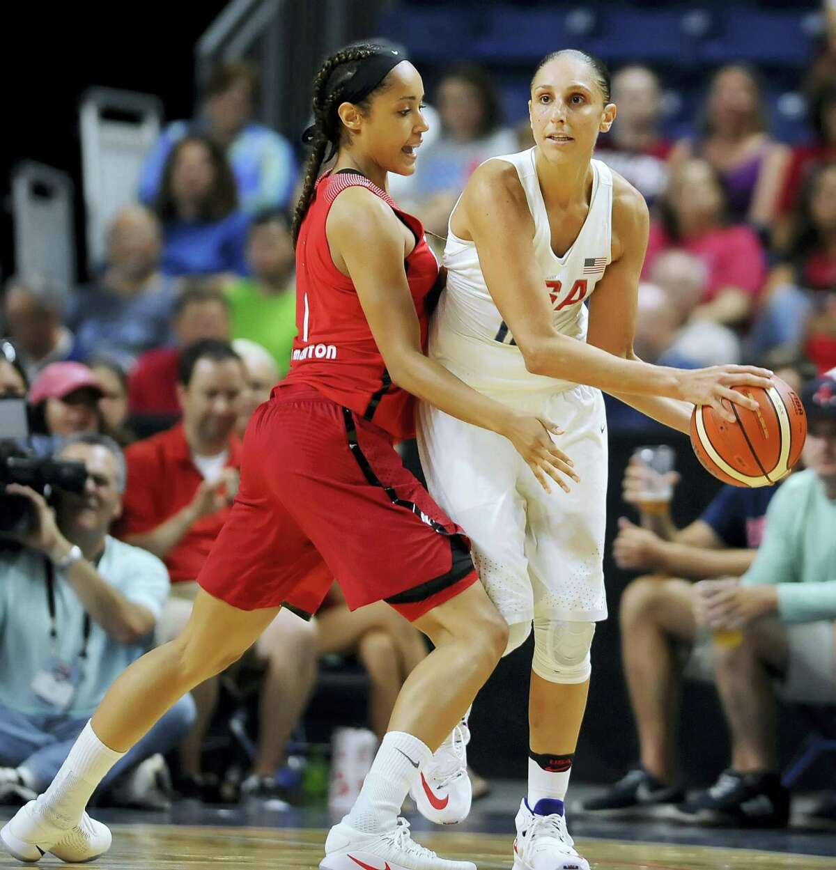 United States’ Diana Taurasi keeps the ball from Canada’s Nayo Raincock-Ekunwe during the first half of an exhibition basketball game Friday in Bridgeport.