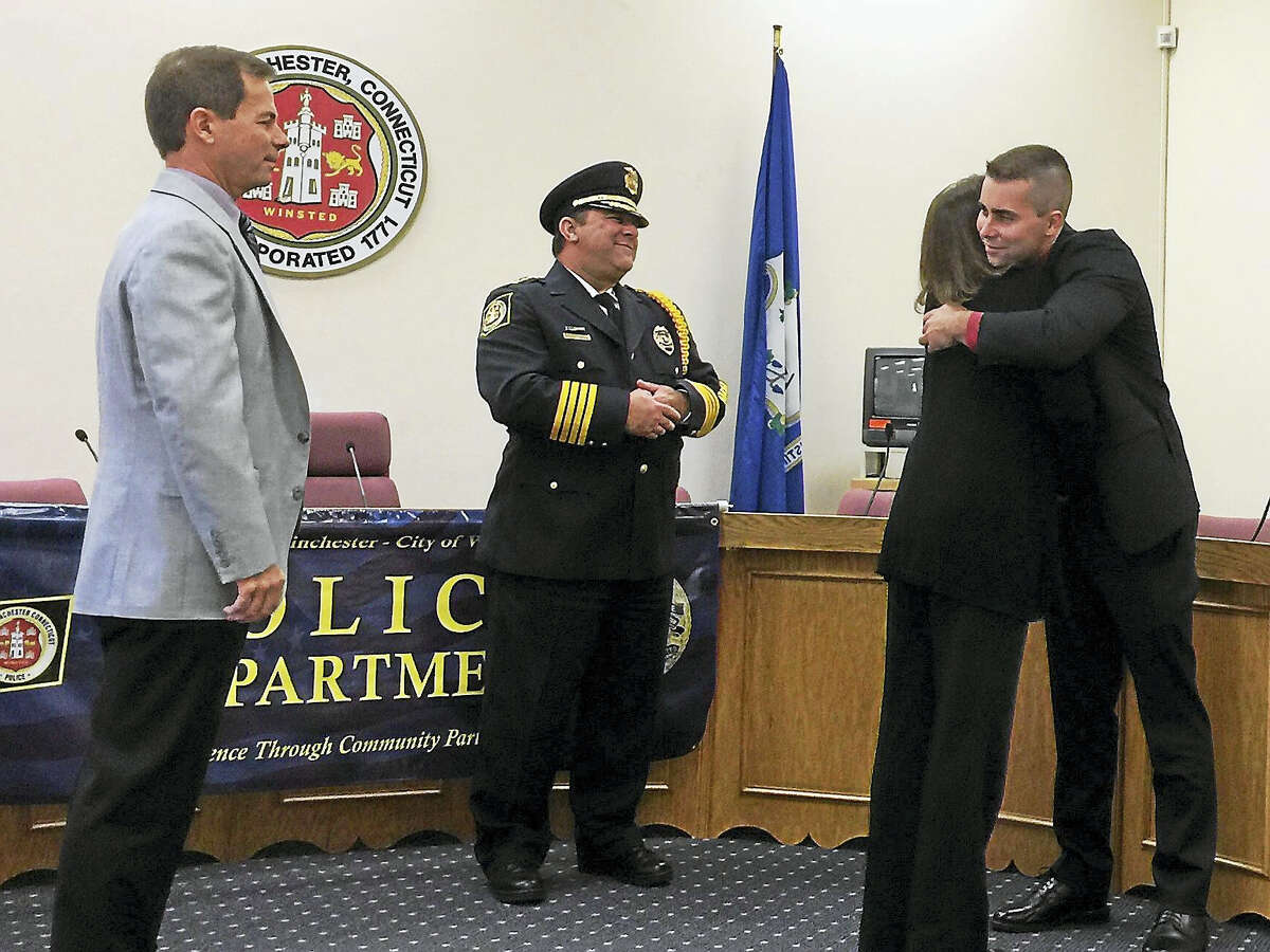 Nicholas C. Ryan, far right, gets a congratulatory hug from his mother, Deborah Ryan, after he was sworn in as a member of the Winchester Police Department Wednesday morning. Also pictured is Police Chief William Fitzgerald, center, and Ryan’s father, Edmond Ryan, left.