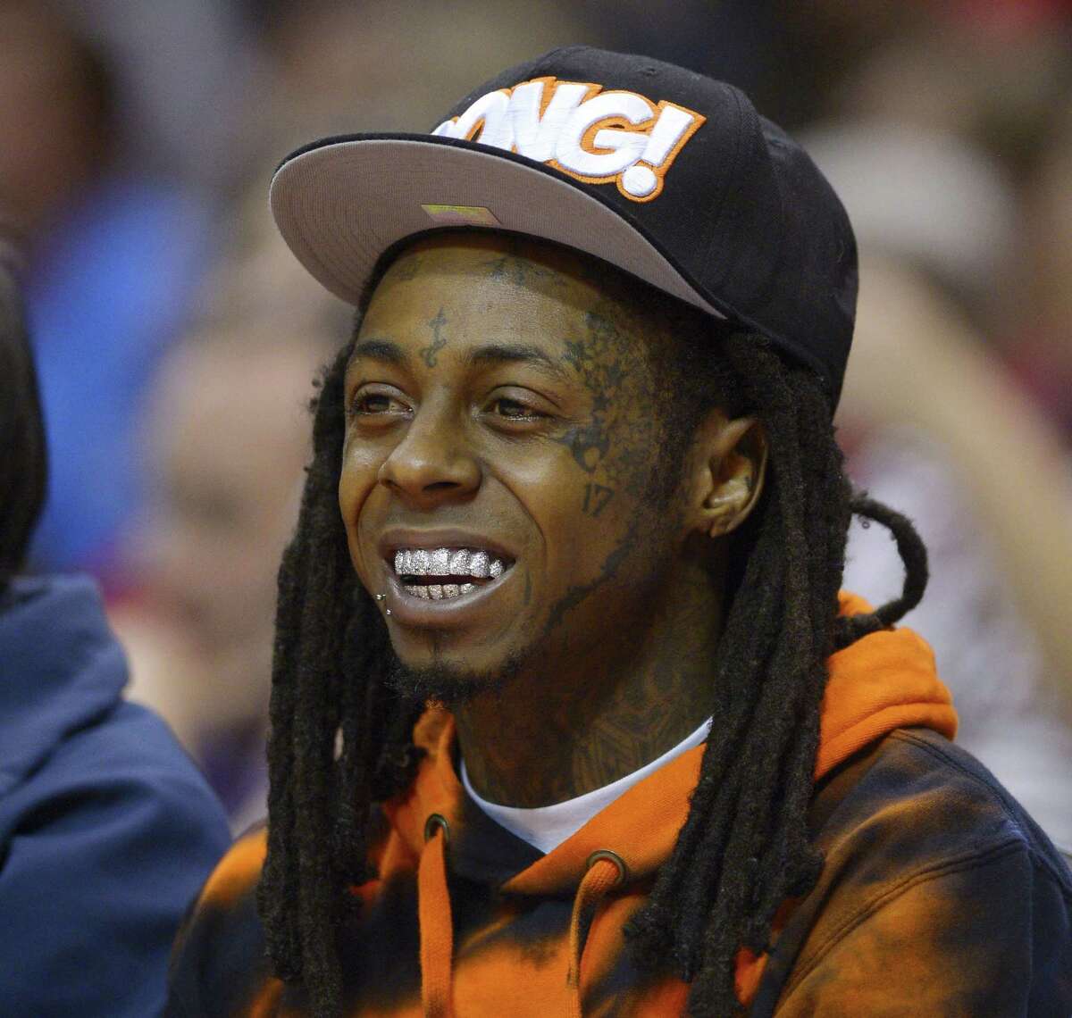 In this 2014 file photo, singer Lil Wayne watches the Los Angeles Clippers play the Houston Rockets during the first half of an NBA basketball game in Los Angeles.
