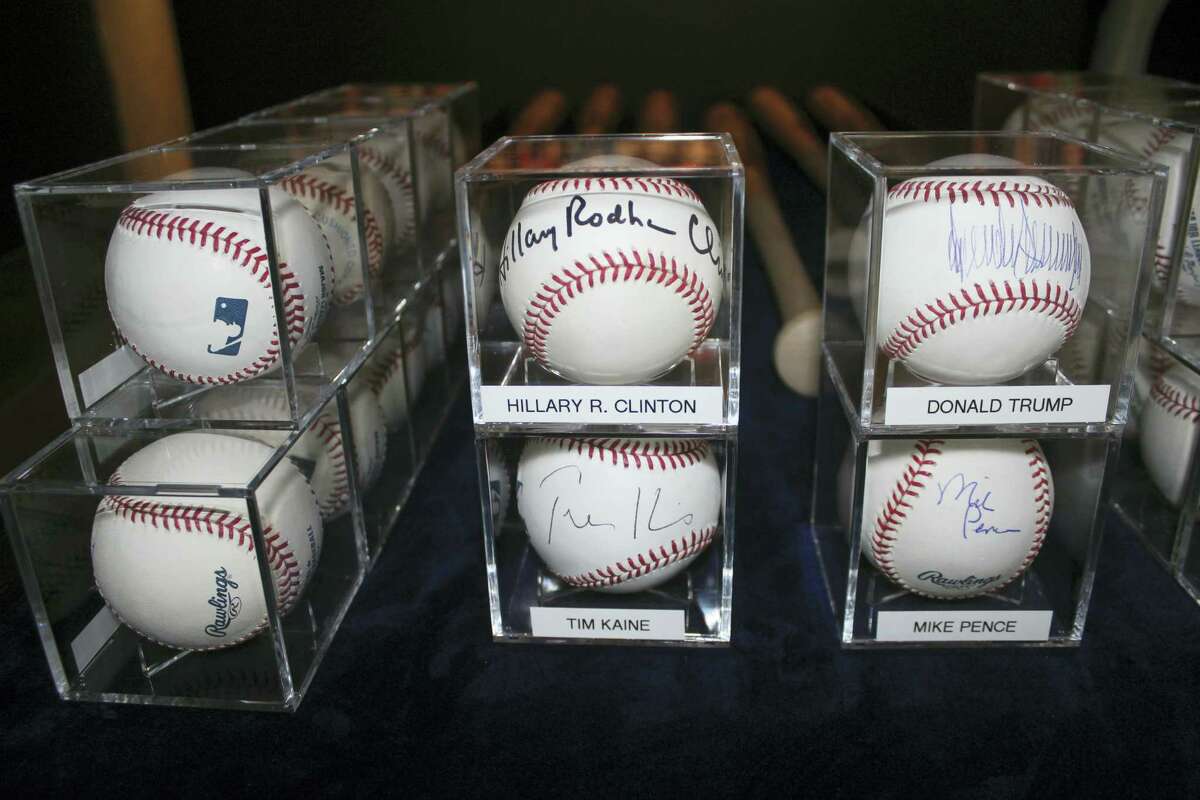 In this photo taken Sept. 30, 2016, autographed baseballs signed by Democratic and Republican presidential candidates Hillary Clinton and Donald Trump, and their running mates Tim Kaine and Mike Spence, are on display in Garden City, N.Y., at the Cradle of Aviation Museum.