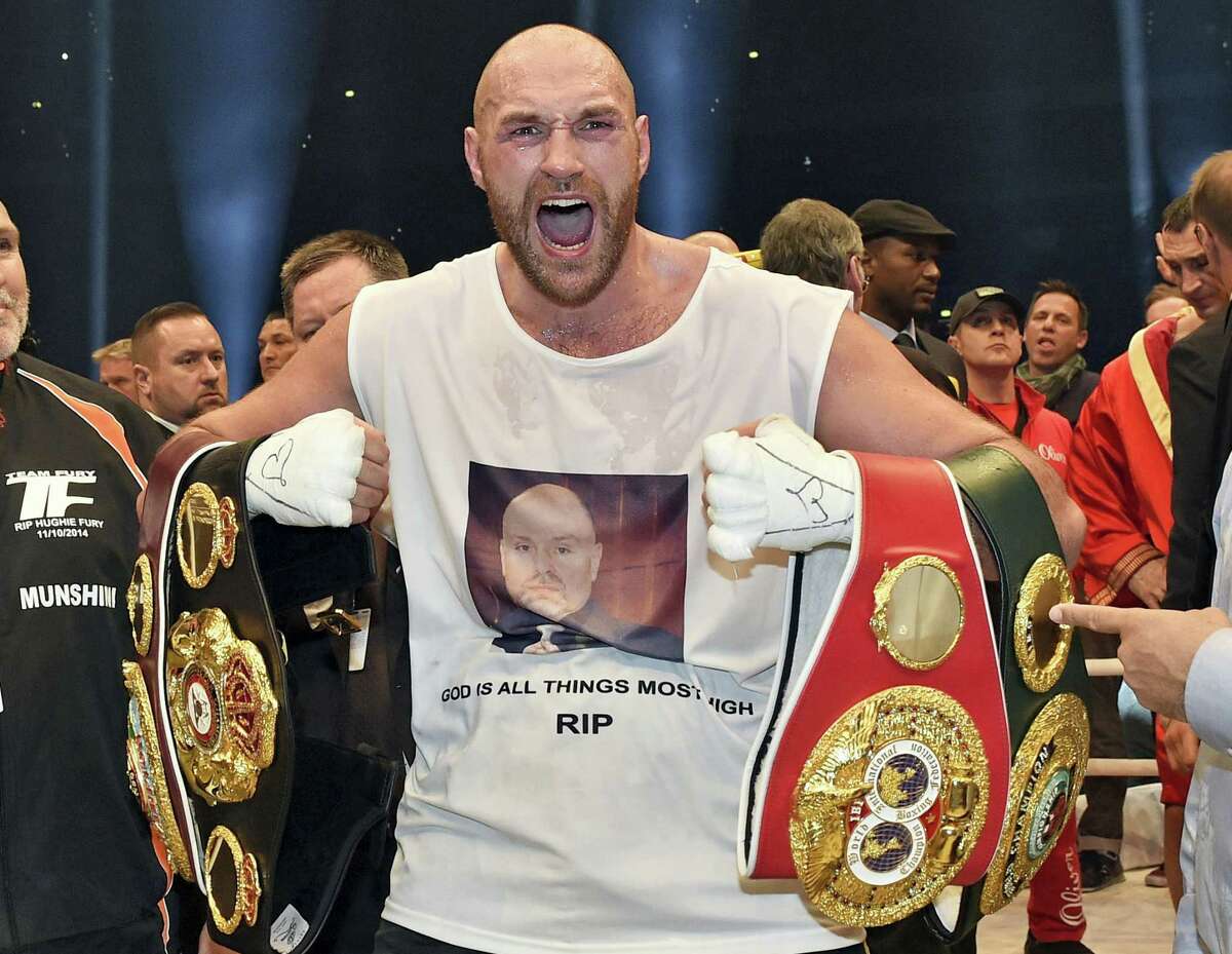 In this Nov. 29, 2015 photo, Britain’s new world champion Tyson Fury, celebrates with the WBA, IBF, WBO and IBO belts after winning the world heavyweight title fight against Ukraine’s Wladimir Klitschko in Duesseldorf, western Germany. Tyson Fury’s boxing career could be over after the reigning IBF, WBO and WBA heavyweight champion announced his retirement in a profanity-filled tweet on Monday Oct. 3, 2016.