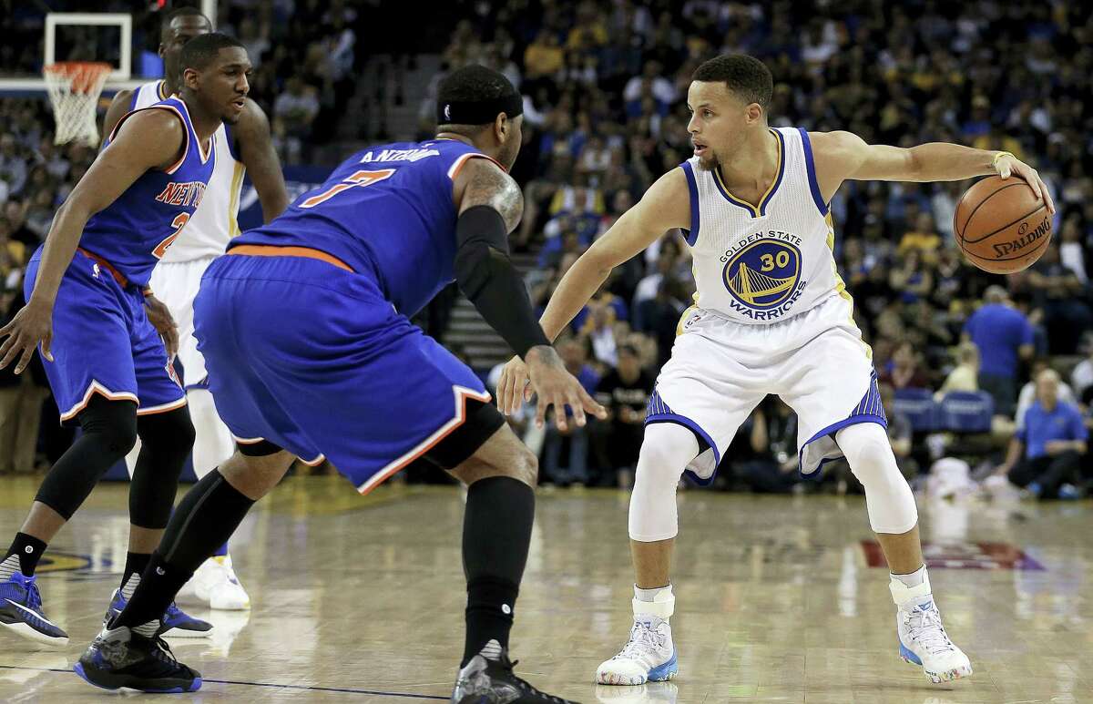 Golden State Warriors' Stephen Curry, right, is defended by New York Knicks' Langston Galloway, left, and Carmelo Anthony (7) during the second half of an NBA basketball game Wednesday, March 16, 2016, in Oakland, Calif. (AP Photo/Ben Margot)