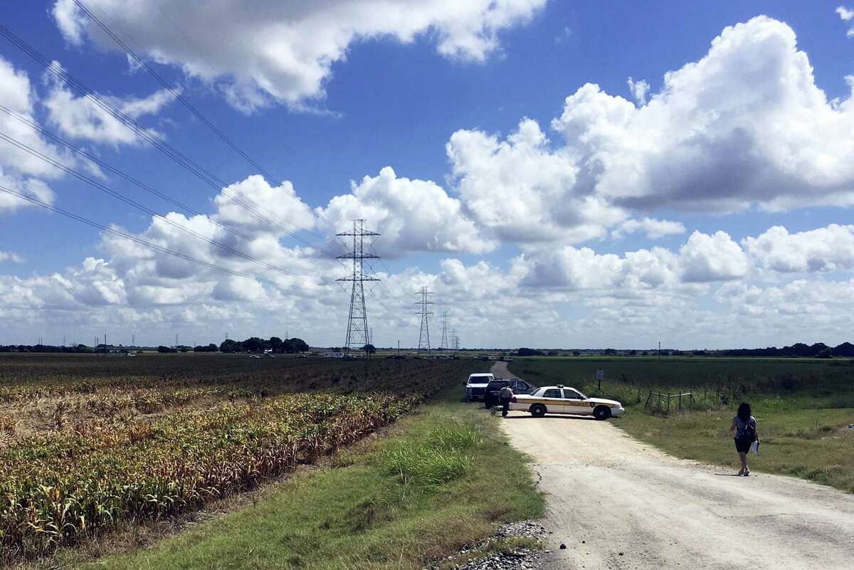 Police cars block access to the site where a hot air balloon crashed early Saturday, July 30, 2016, near Lockhart, Texas. At least 16 people were on board the balloon, which Federal Aviation Administration spokesman Lynn Lunsford said caught fire before crashing into a pasture shortly after 7:40 a.m. Saturday near Lockhart. No one appeared to survive the crash, authorities said.