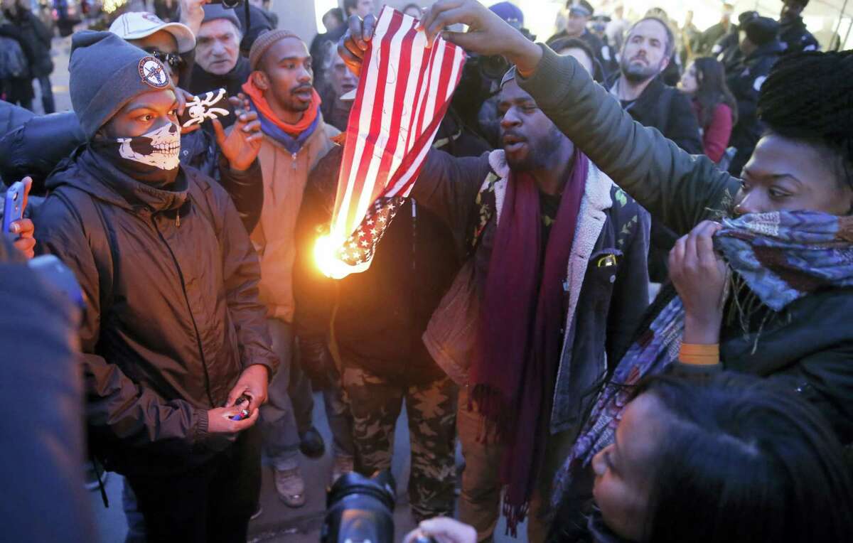 In this Feb. 23, 2016, file photo, protesters burn an American flag in Chicago. Champaign County Ill., State’s Attorney Julia Rietz was alerted on July 4, 2016, that police had just arrested a resident on suspicion of burning an American flag. Rietz said she knew “immediately” that the Urbana Police Department needed to release him. The state law used to jail him, though clear in its prohibition of desecrating either the U.S. or state flags, is unconstitutional.