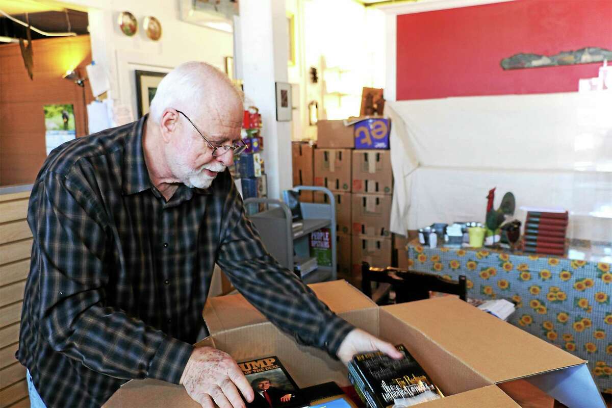 Bob Schwalb works on packing books and Dickens Books and Art, which closed last month.